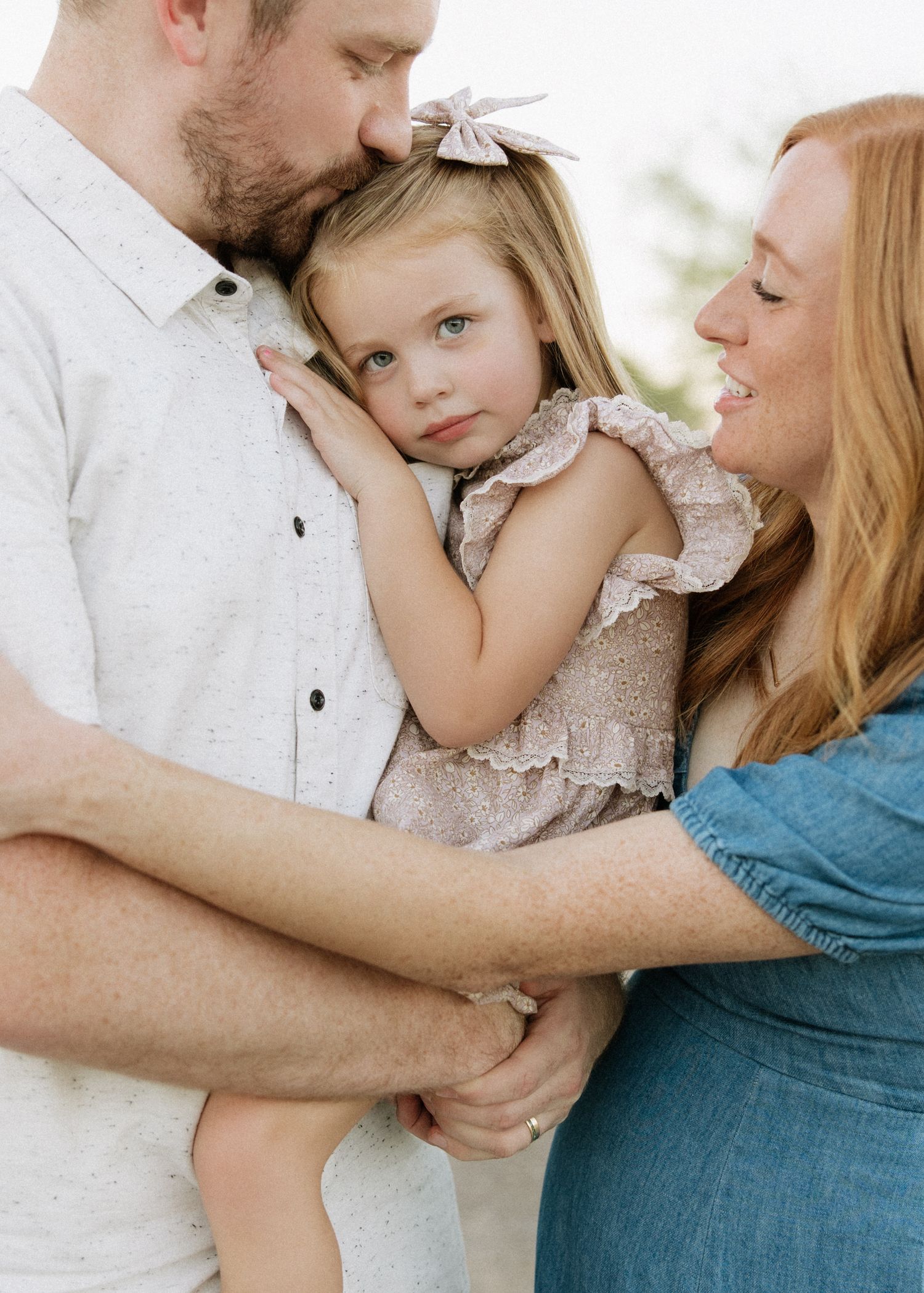A tender family moment captured during an outdoor portrait session.