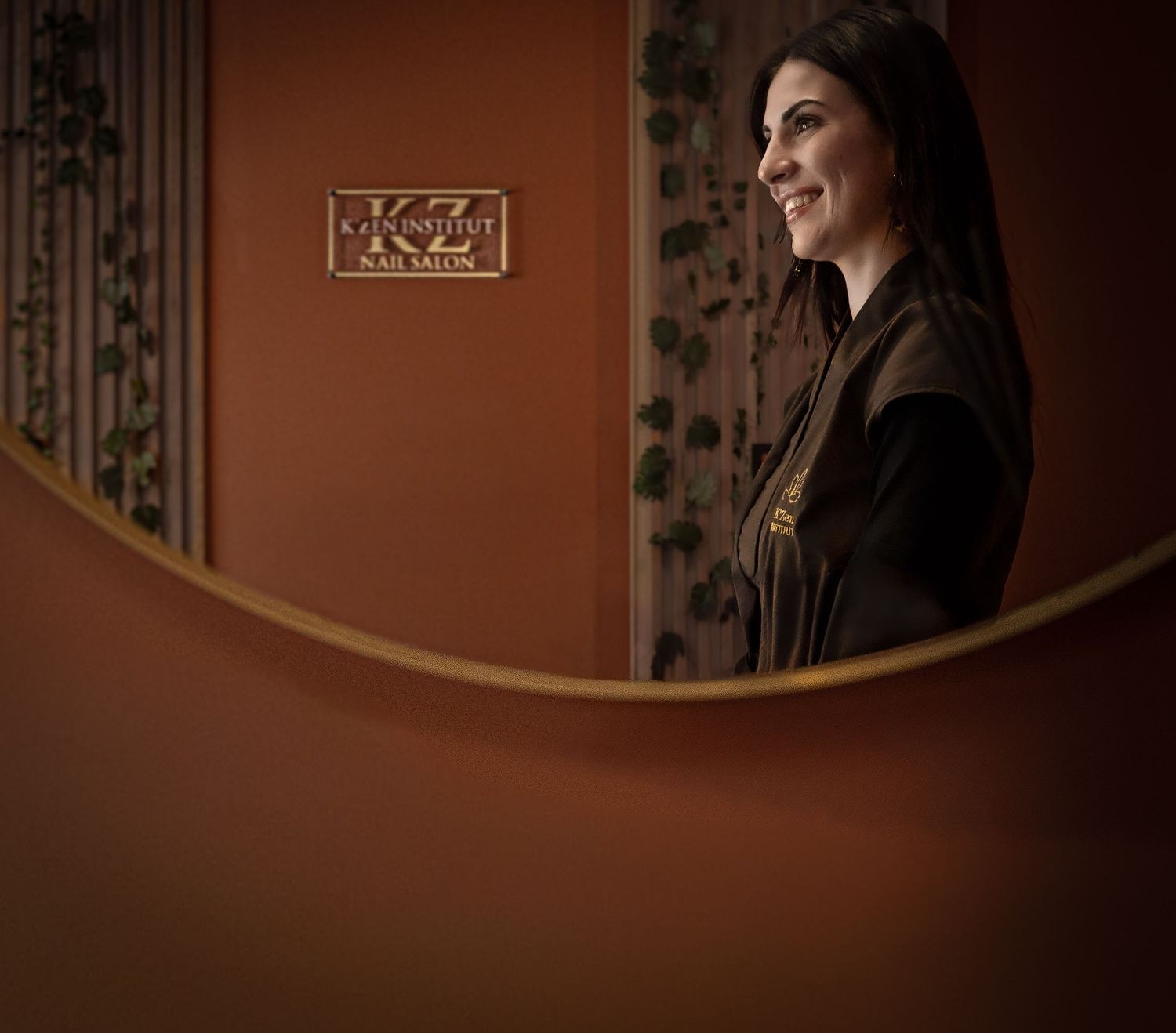 Portrait de la gérante de l'institut de beauté avec le logo de sa boutique. Reflet miroir, tons chauds et ambiance chaleureuse.