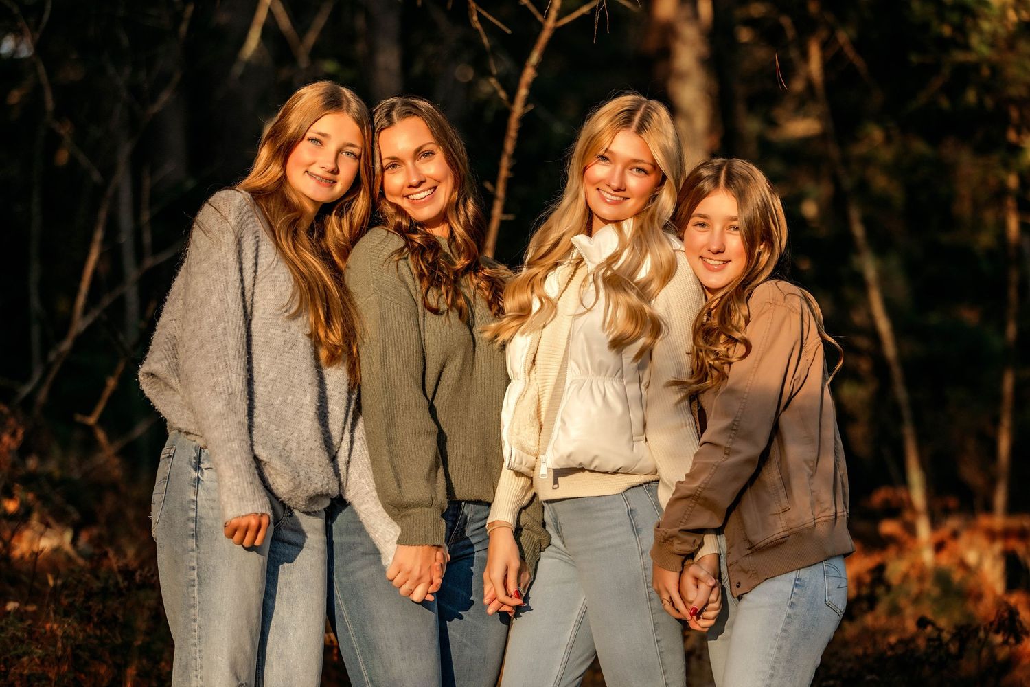Mom and daughters holding hands during golden hour photos in Central NY