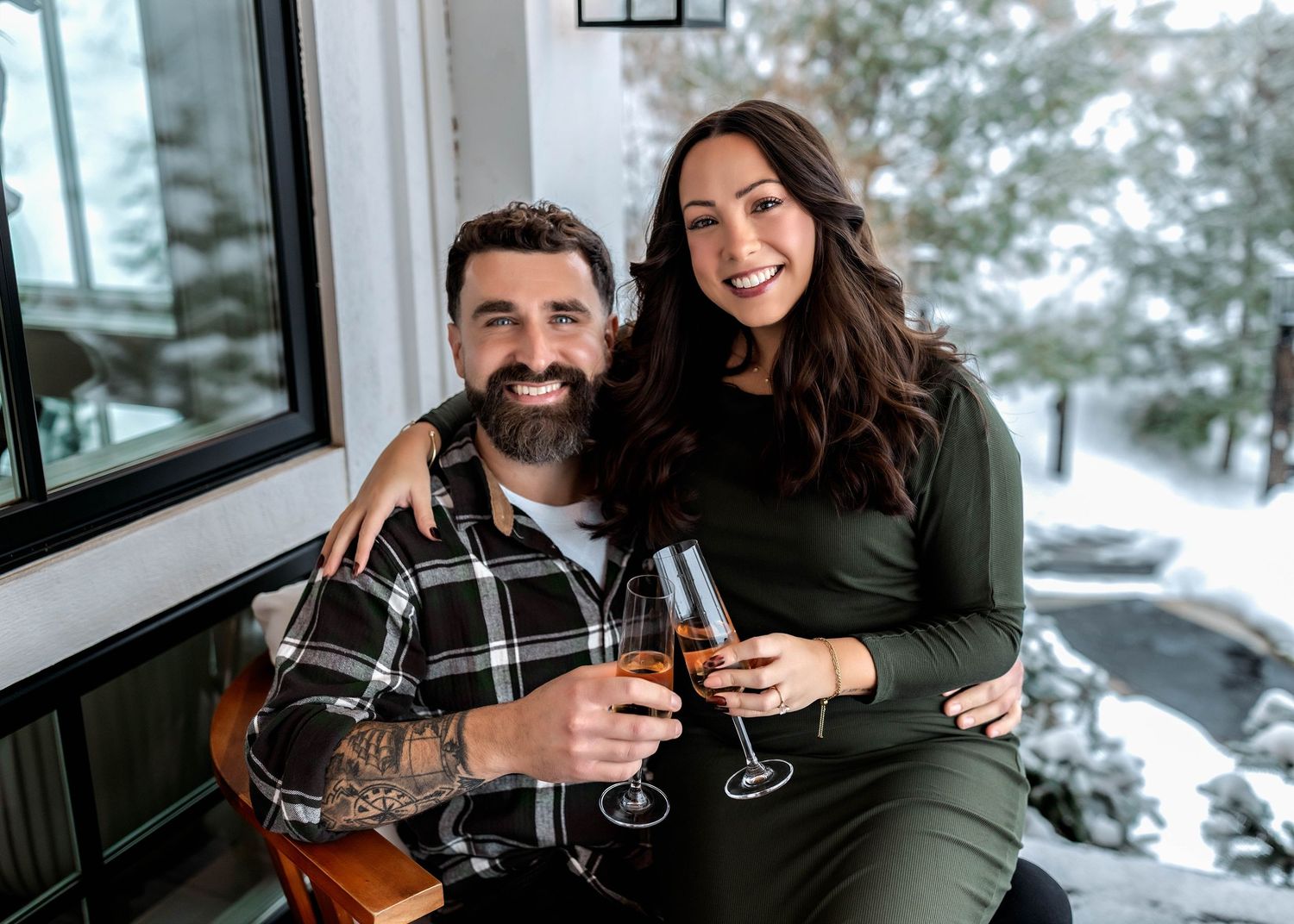 Couple touching champagne flutes during winter engagement session in Central NY