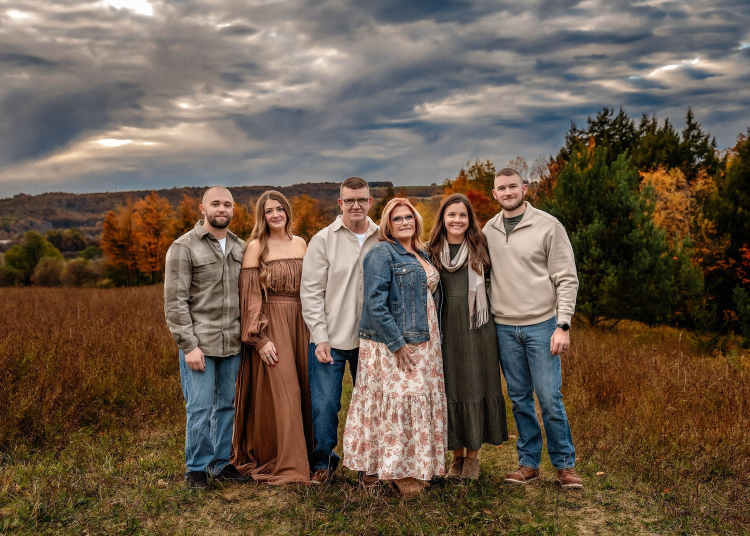 Styled Generational family photo in a field in Central NY with stormy sky