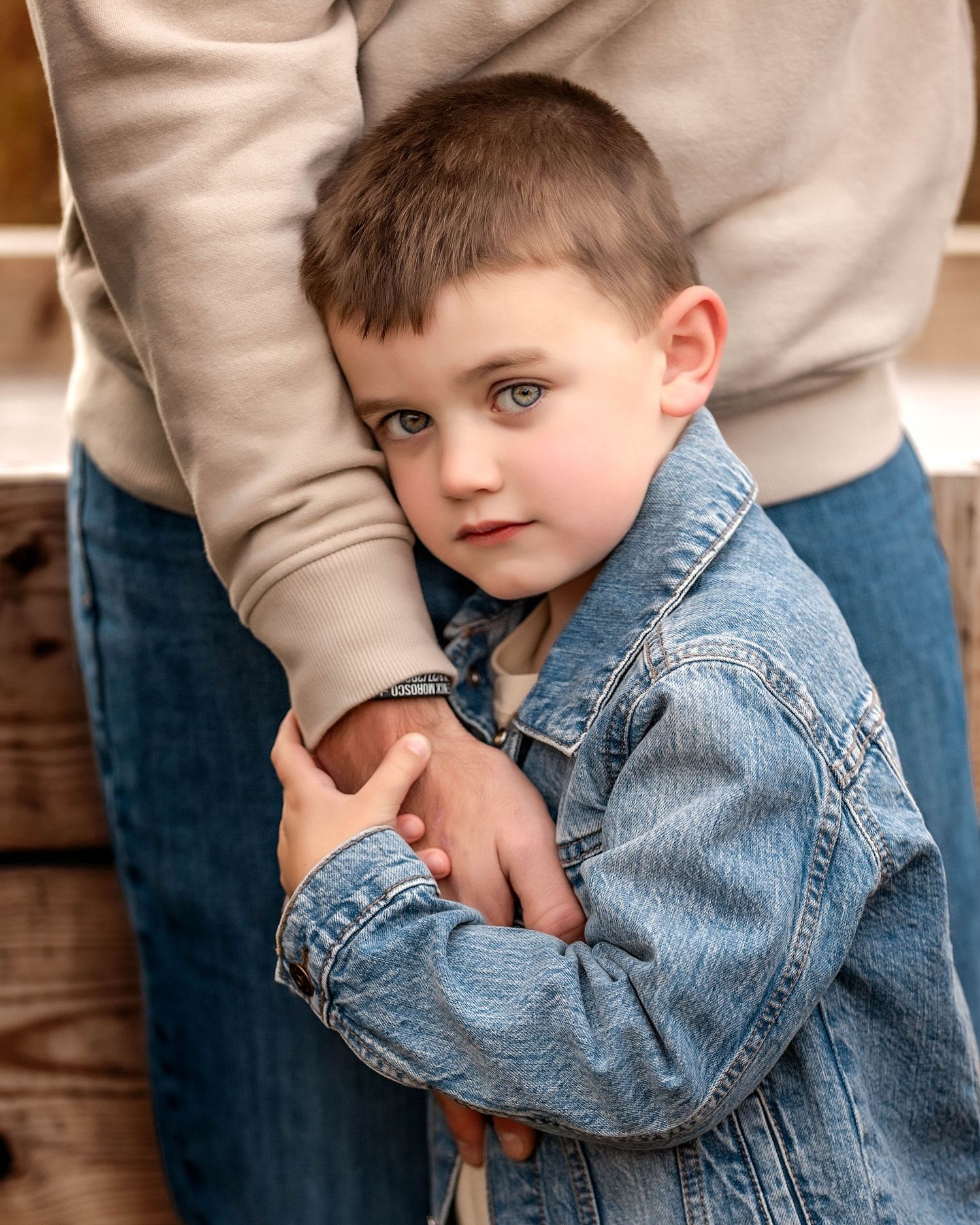 Son holding his father's hand and hugging his arm in Central NY
