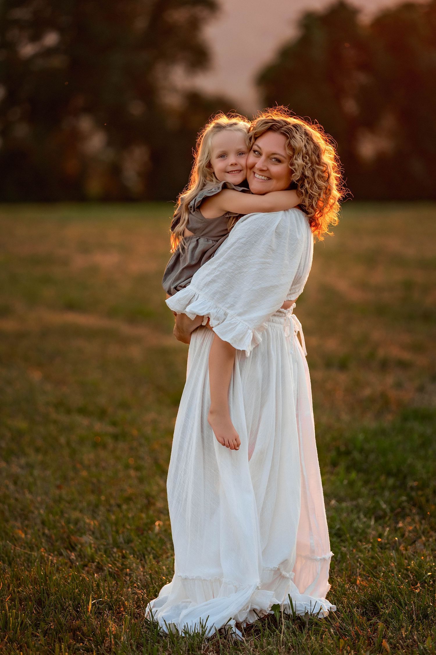 Mother holding child in a field during golden hour photos