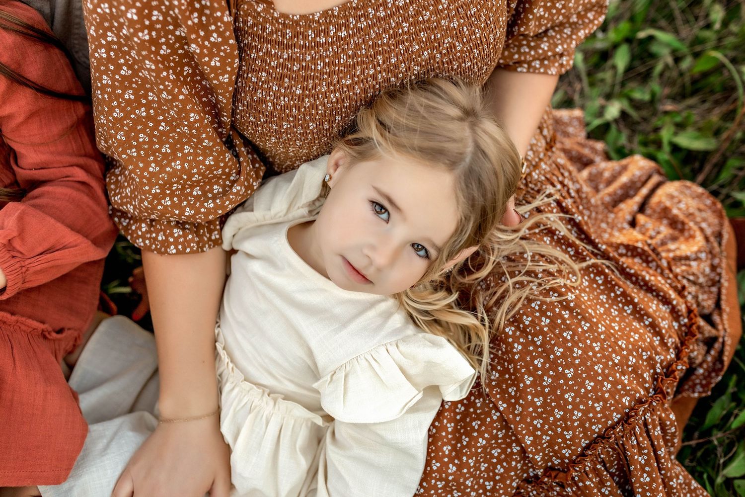 Child laying on mothers lap during family photo session in CNY