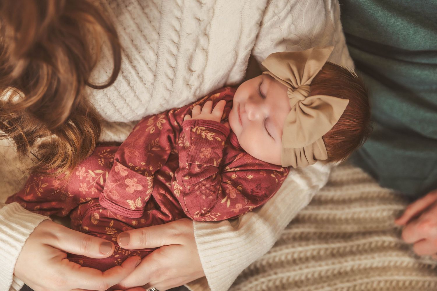 Newborn baby being cradled in her mothers arms during lifestyle newborn photos in studio in Central NY