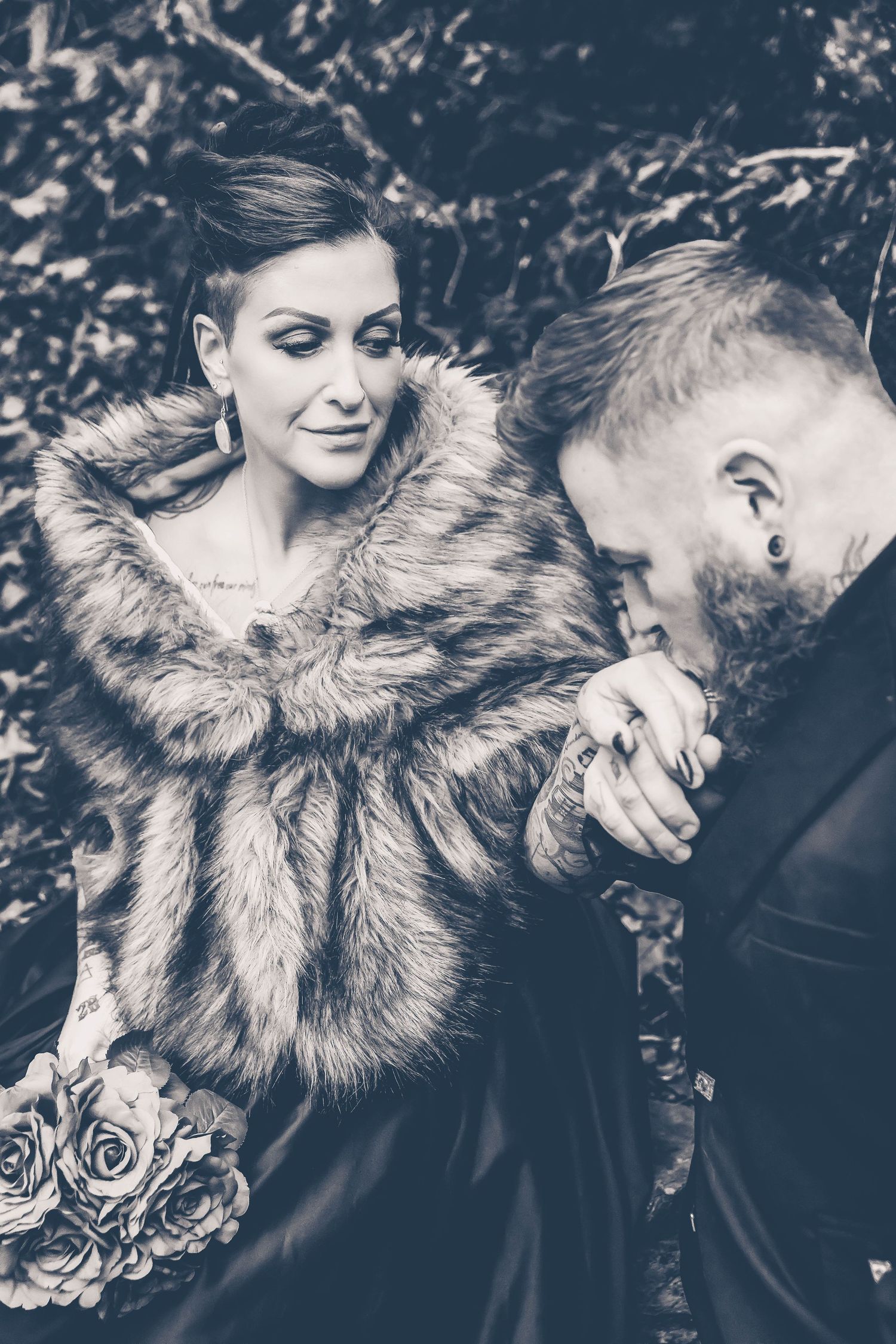 Husband kissing wife's hand during wedding photos