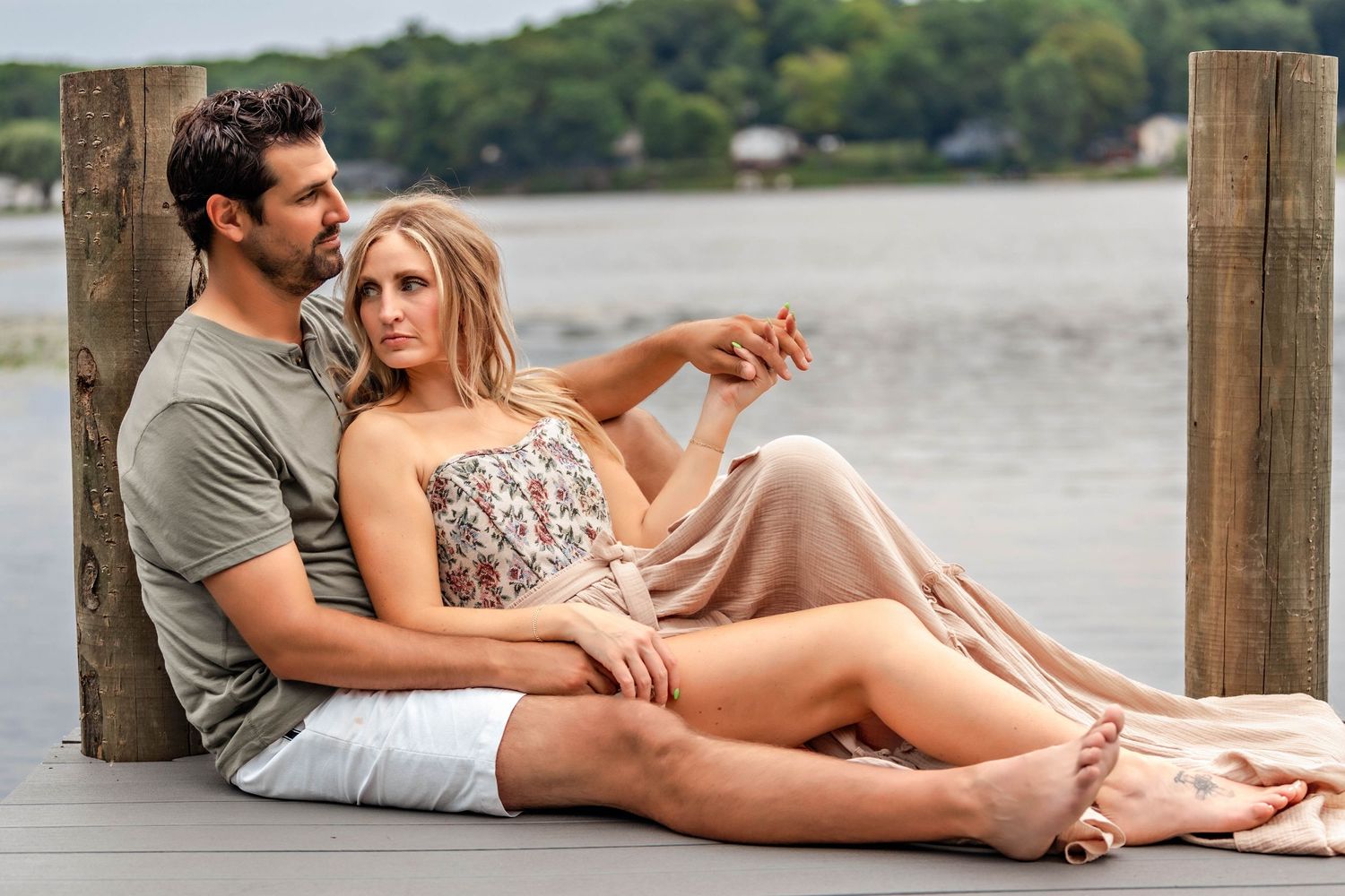 Couple sitting together on the dock in front of a lake in Central NY