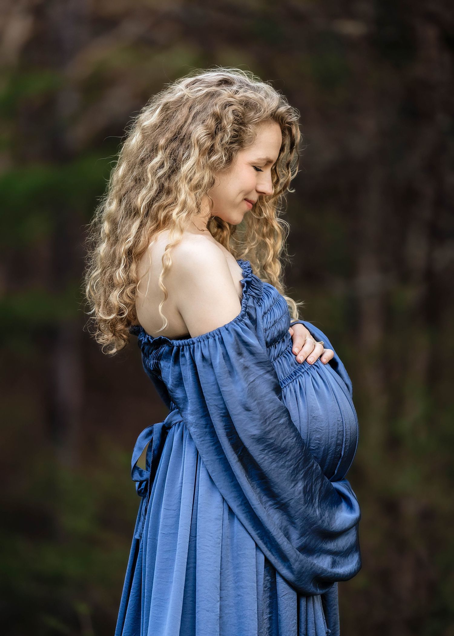 Mother cradling her pregnant belly during maternity photos in central NY