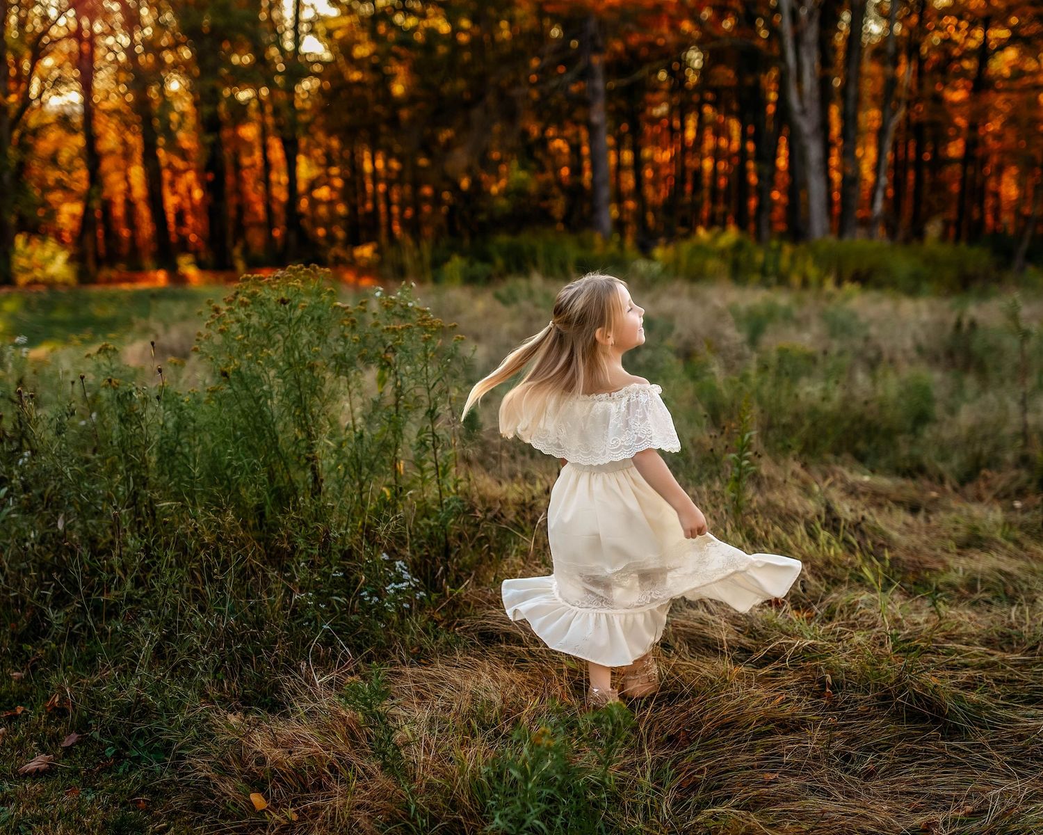 young girl twirling in a white dress with a field and trees in Madison county NY