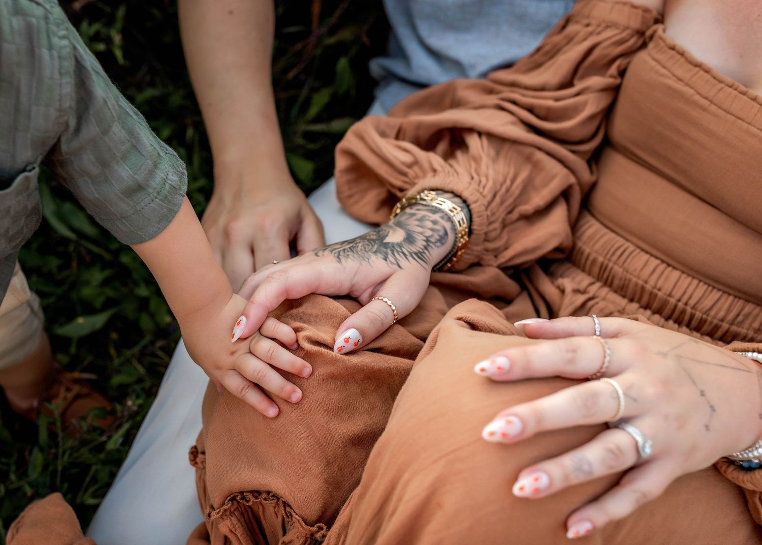 Close up of parents and toddler son holding hands