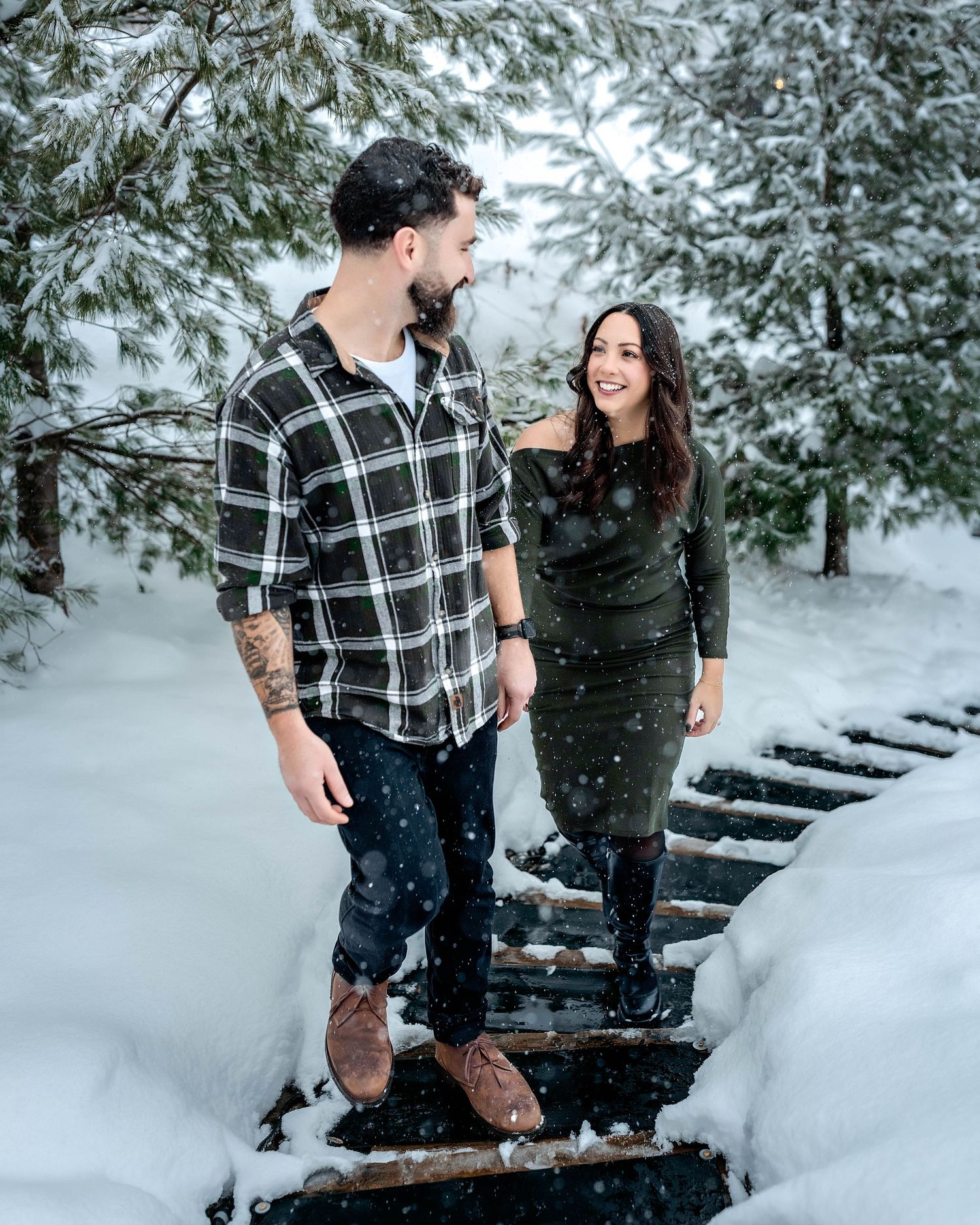 Couple holding hands and walking up stairs during a winter engagement session at Hinkley Reservoir, NY