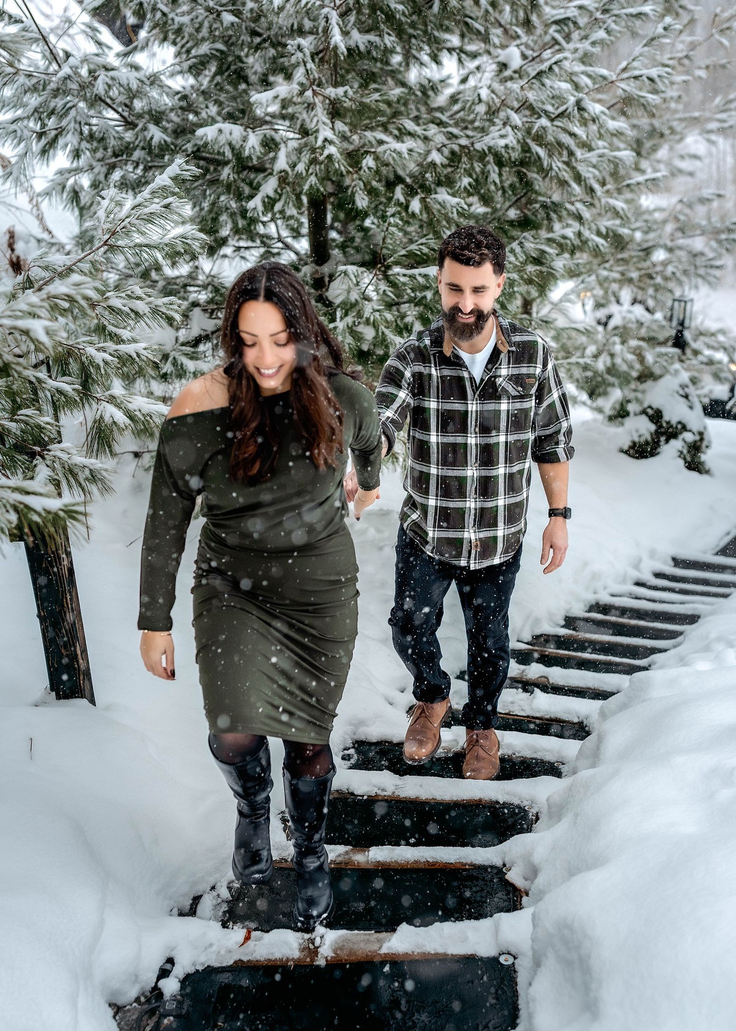 woman leading man by the Hand up the stairs with a snowy background