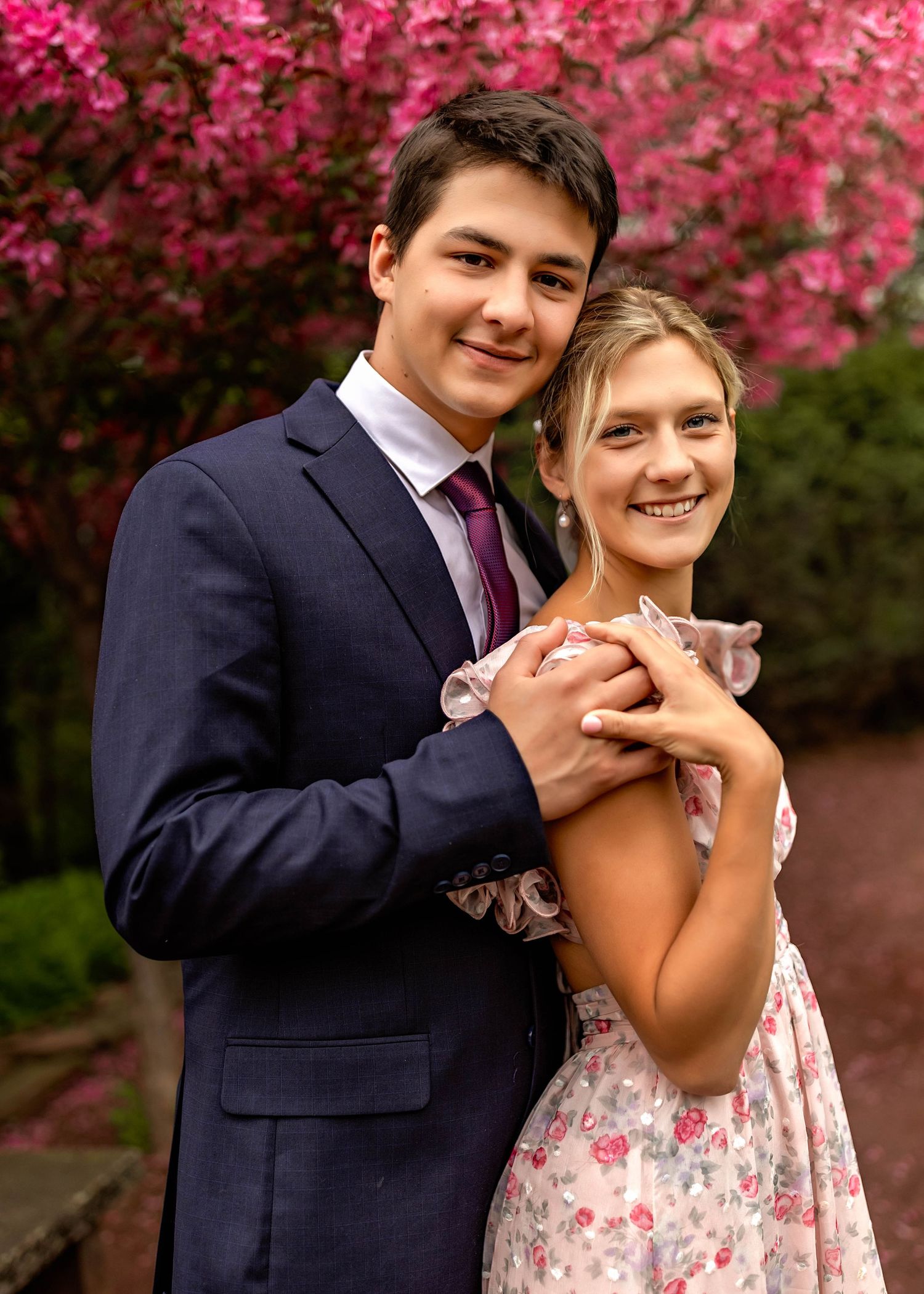 Engagement photos in front of apple blossoms in spring in Central NY