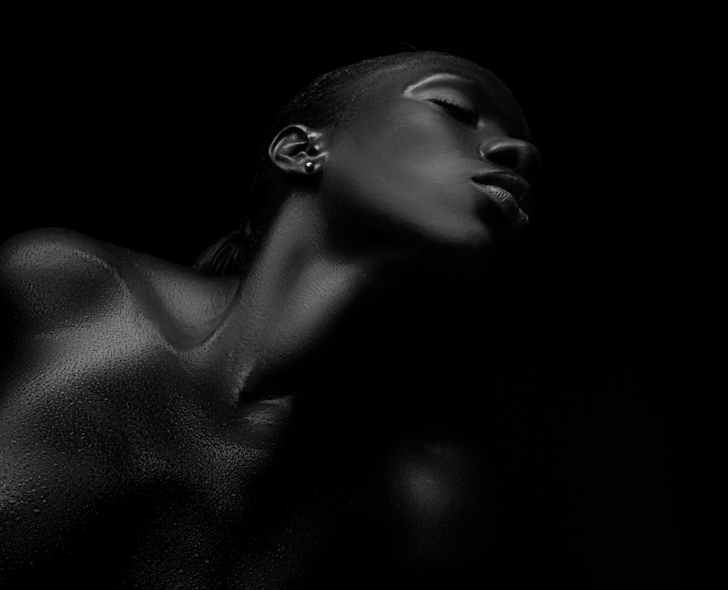 A dramatic black and white portrait showing silhouetted profiles and facial features against dark shadows.