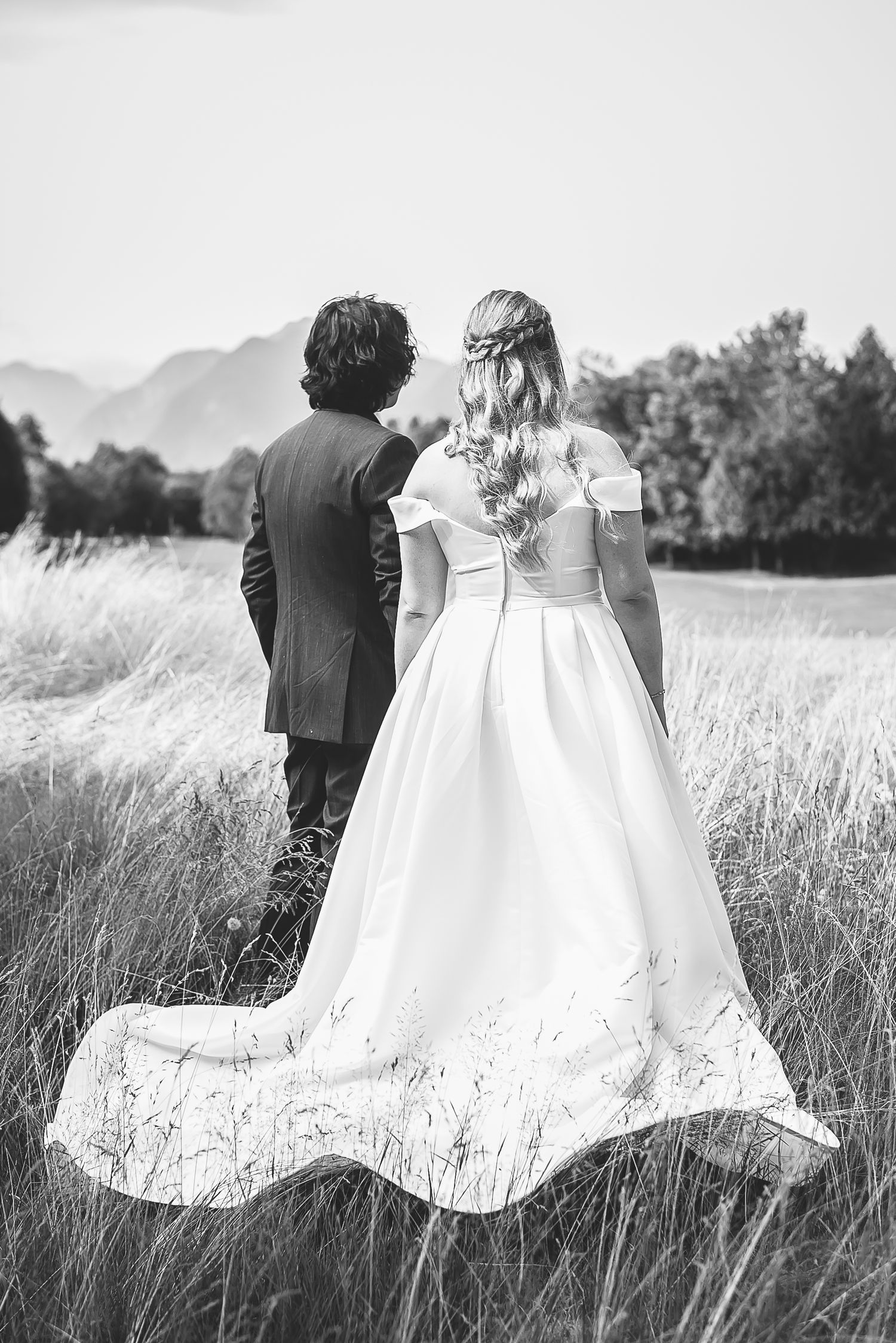 Black and white image of a couple on their wedding day at Golden Eagle Golf course in Pitt Meadows, gazing out to the mountains.