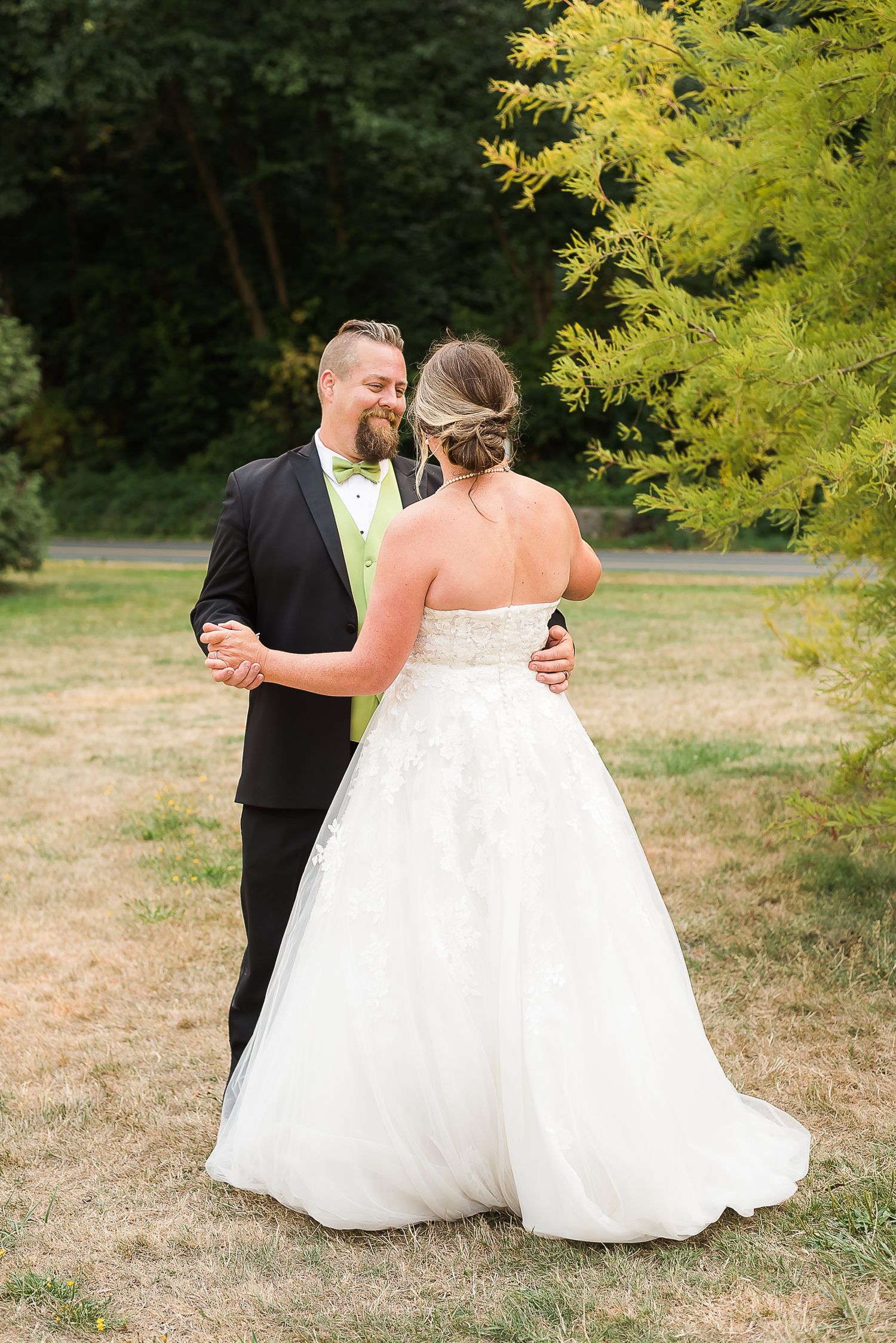 A bride and groom share a dance outside on the grass during their wedding portraits. Vancouver, BC.