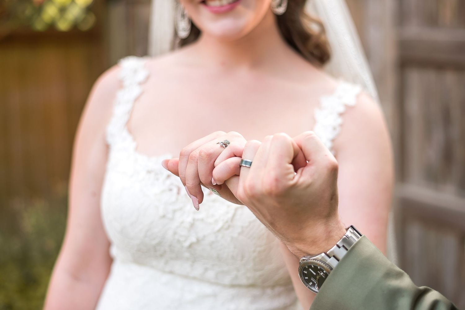 A close up photo of  bride and groom doing a pinky promise, featuring the wedding rings on their fingers. Photo taken in Lindell Beach, BC.