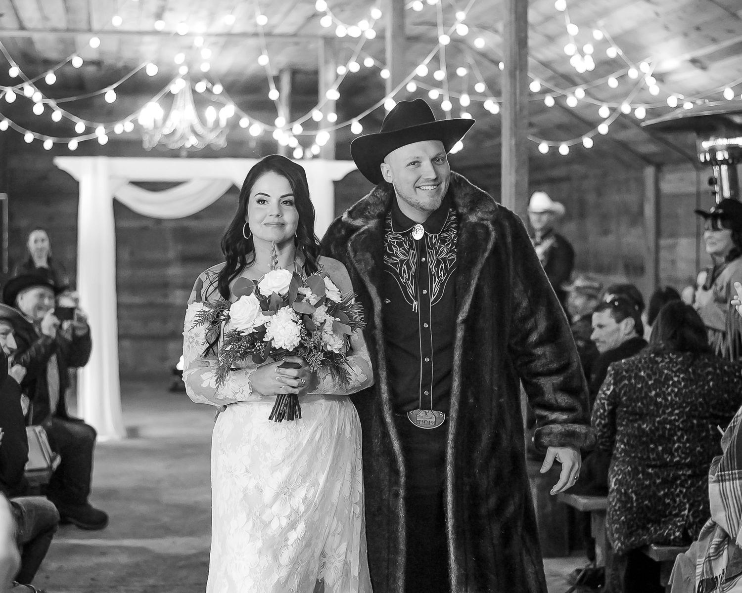 A black and white image of a couple smiling widely as their walk down the aisle together after their rustic barn ceremony in Langley, BC.