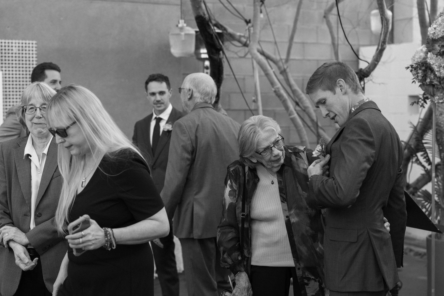 Guests mingling at an outdoor wedding reception in black and white photography.