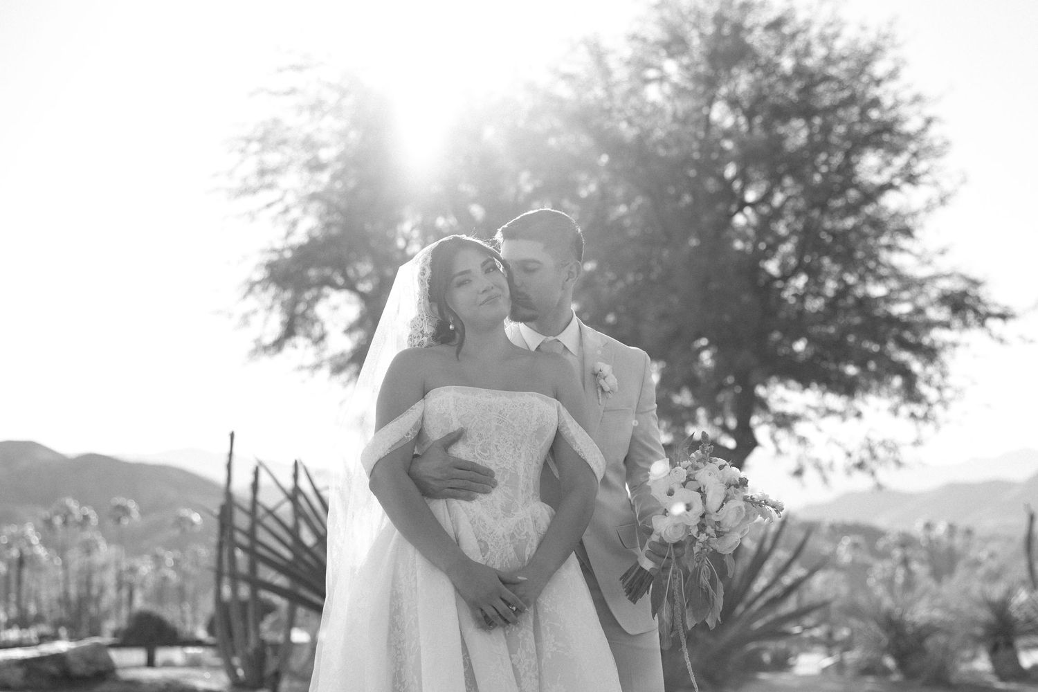 Wedding ceremony setup outdoors with white chairs and floral arrangements.