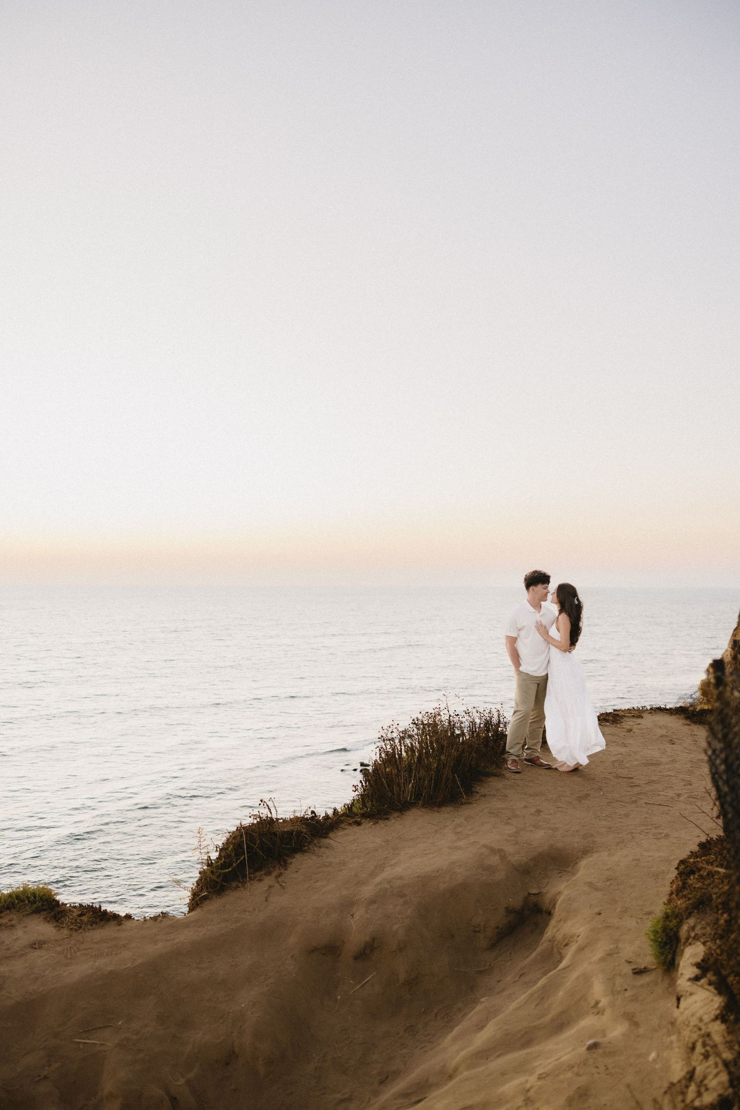 Coastal cliff overlooking the ocean at sunset with dramatic natural lighting.