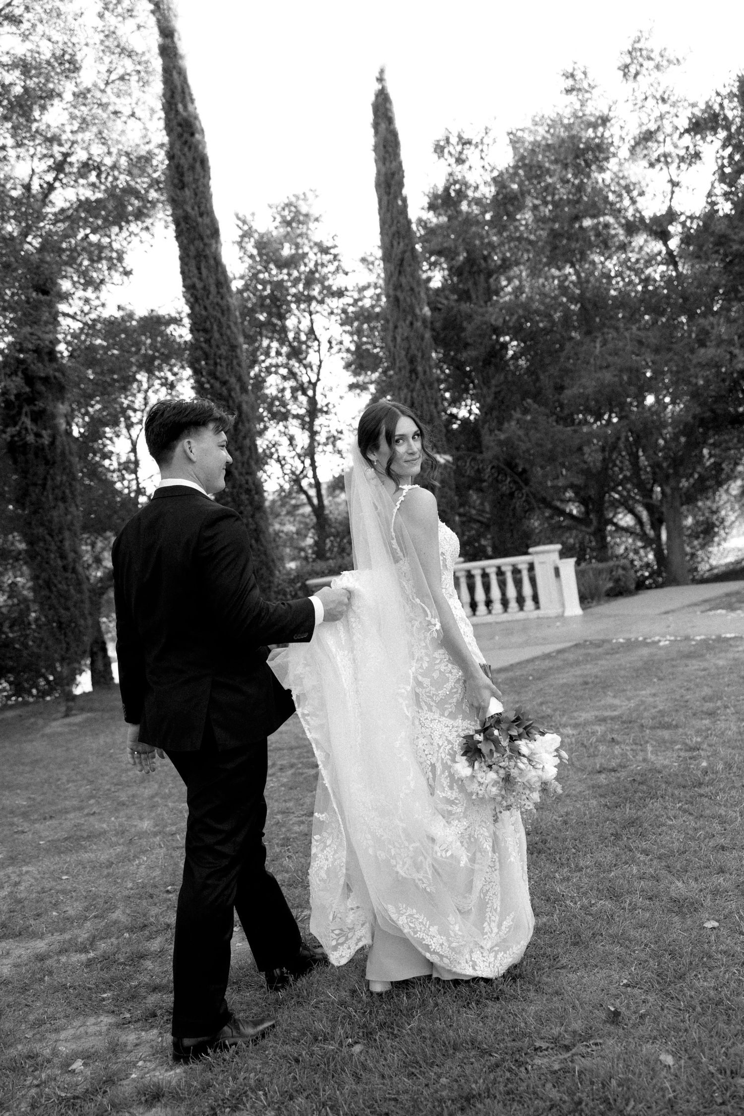 Black and white sequence of a couple dancing playfully in a garden setting with flowing wedding attire.