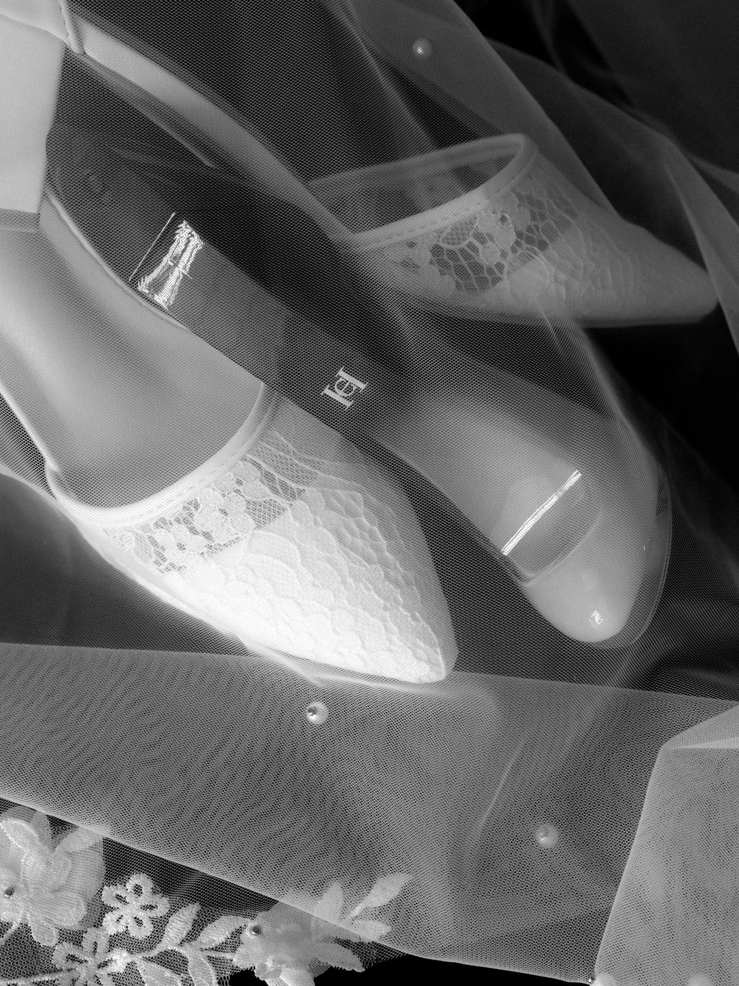 Detailed shot of elegant white bridal shoes with lace detailing.