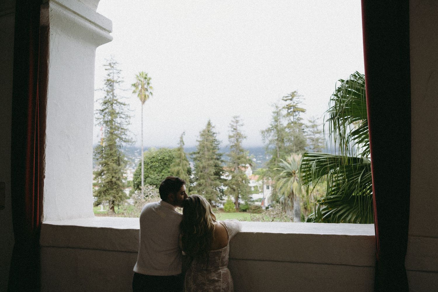 Panoramic view through large windows overlooking distant mountains and trees.
