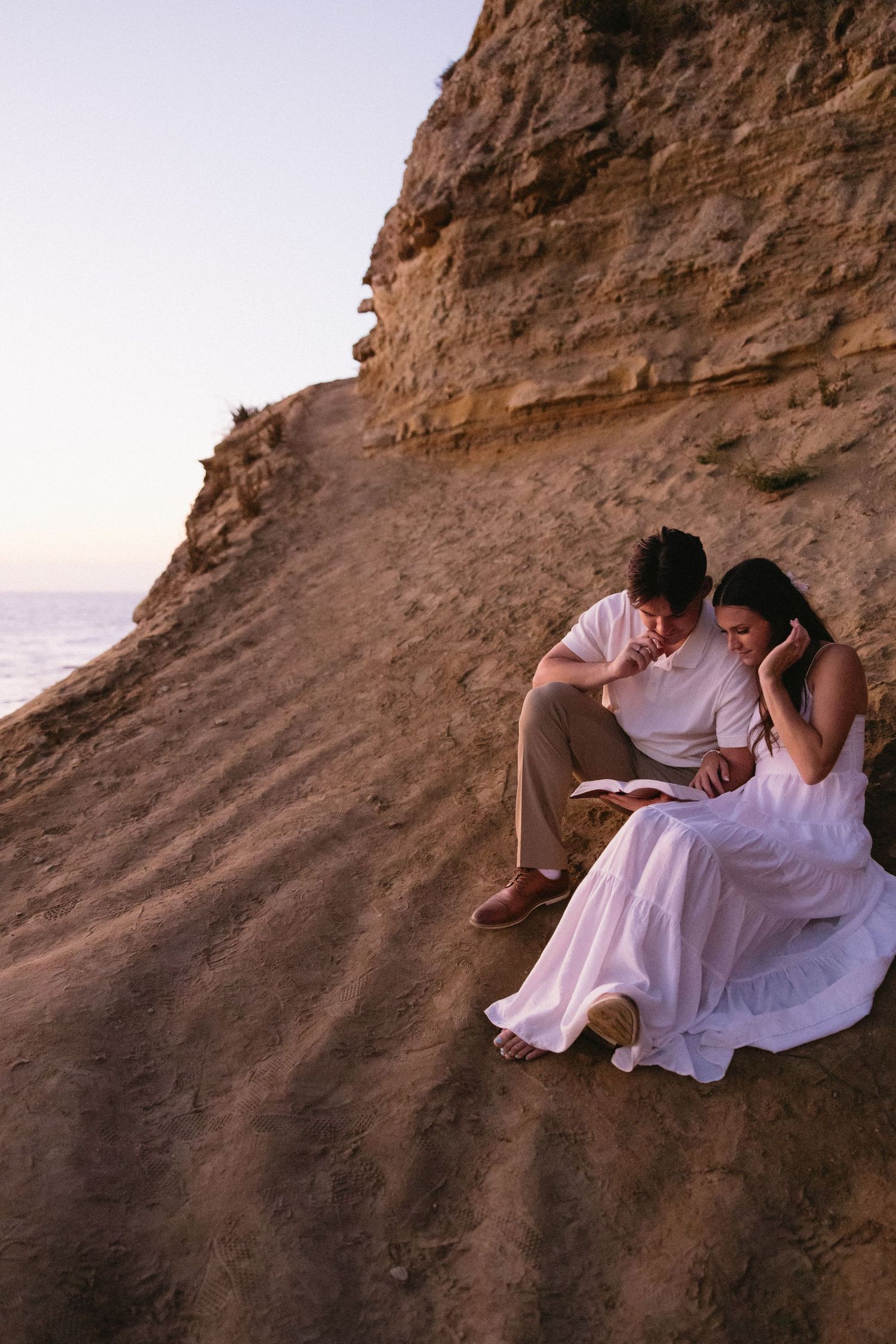 Rocky coastal cliff edge against ocean backdrop during golden hour.