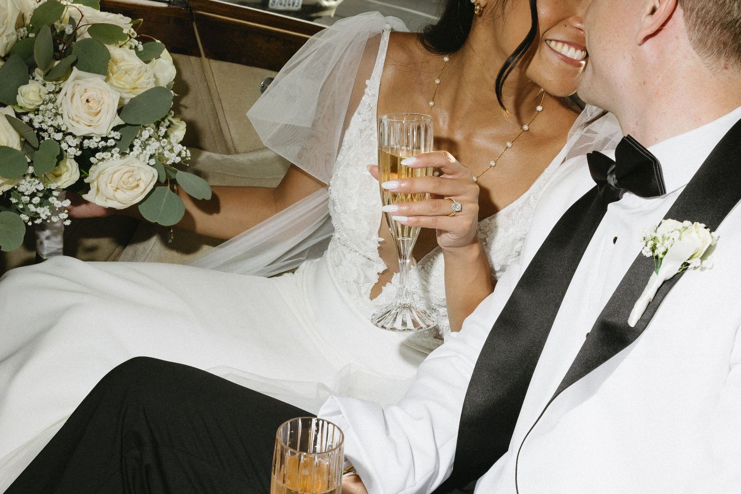 A couple in wedding attire sharing champagne together in an intimate moment.