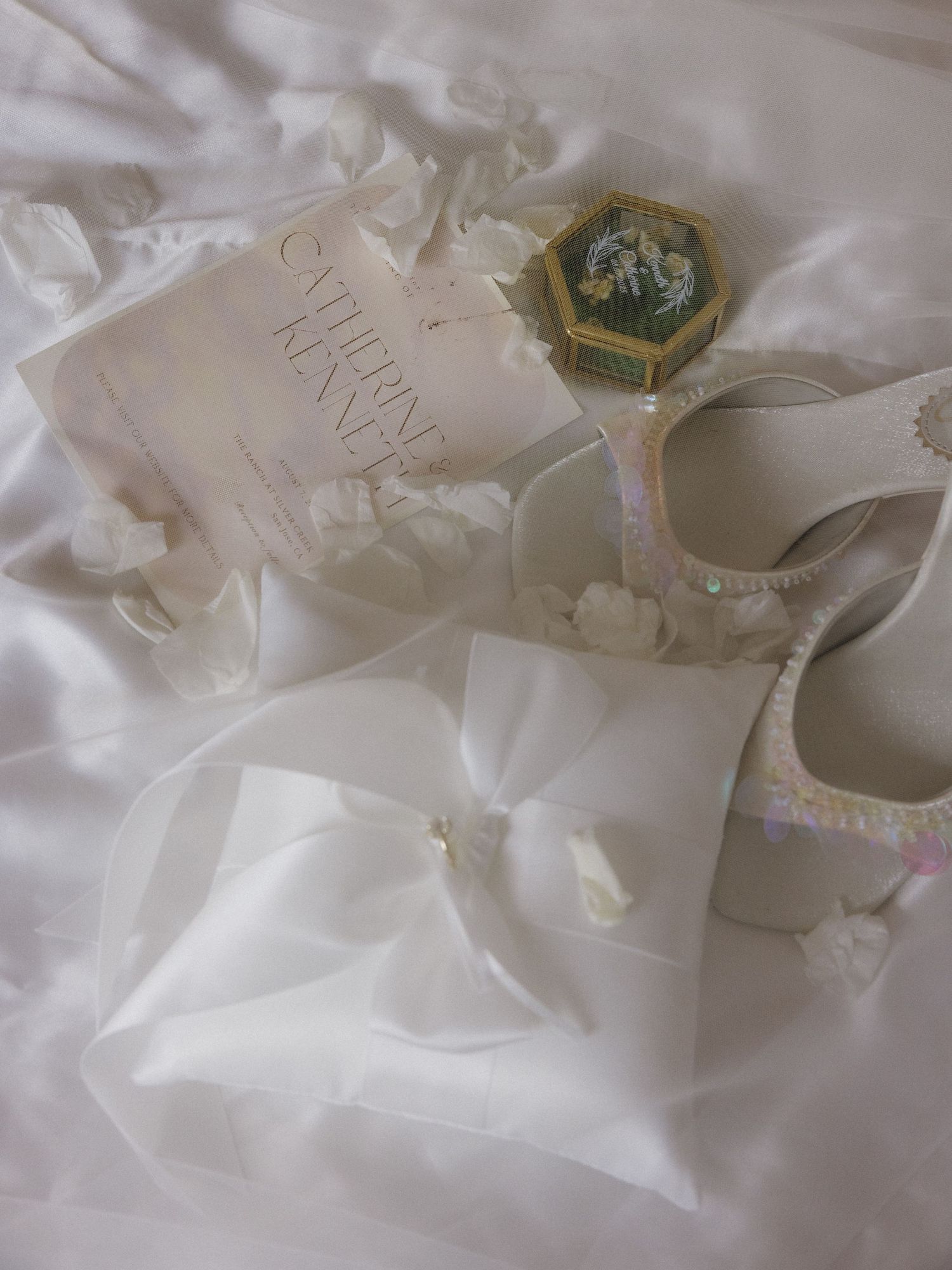 White wedding favors and decorative items arranged on a light colored surface.