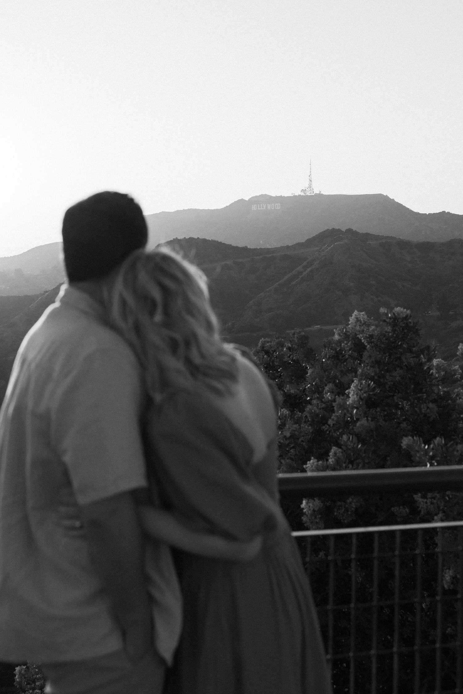 Silhouetted couple overlooking Los Angeles from Griffith Observatory viewpoint.