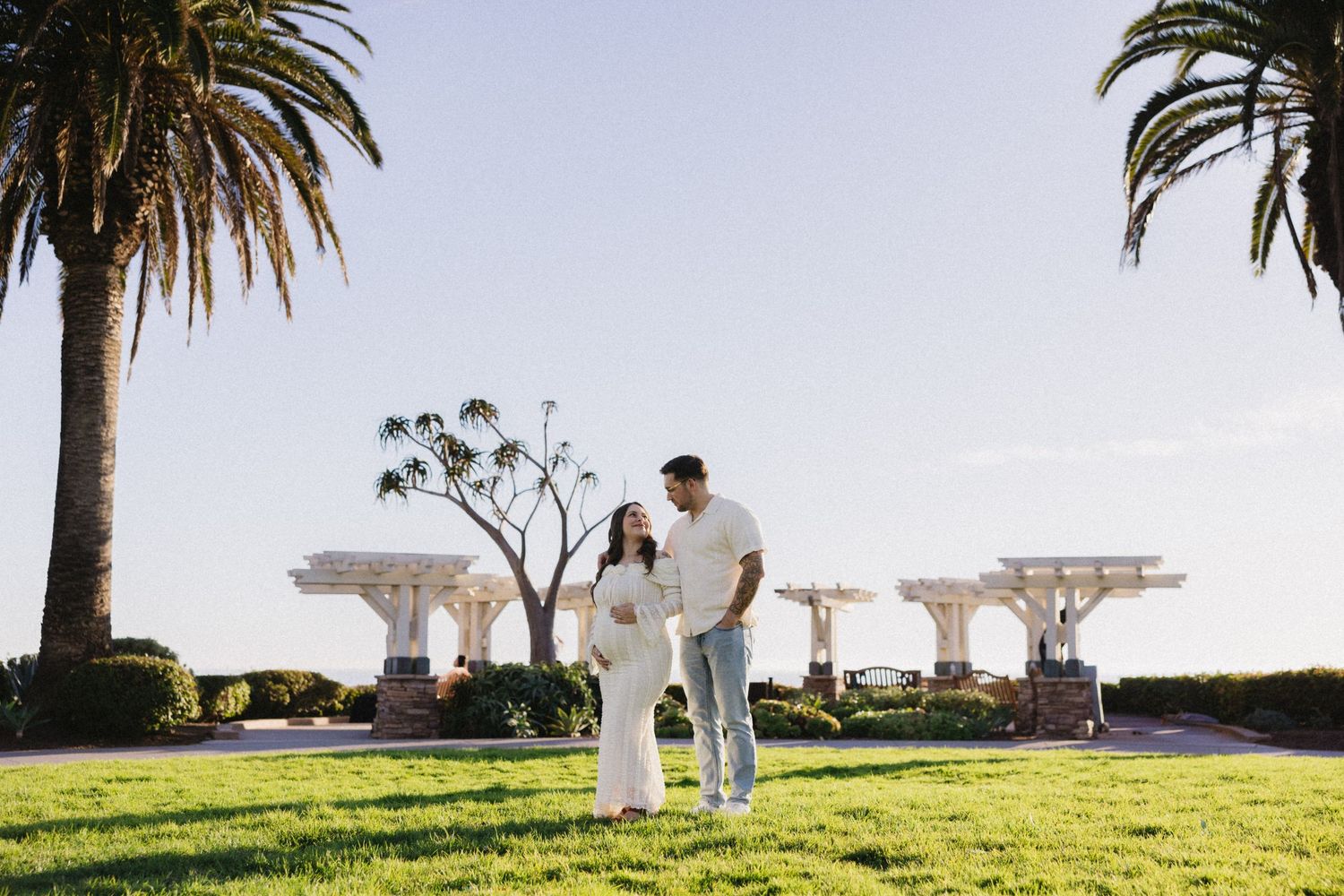 Palm trees frame a scenic outdoor gathering against a bright blue sky.