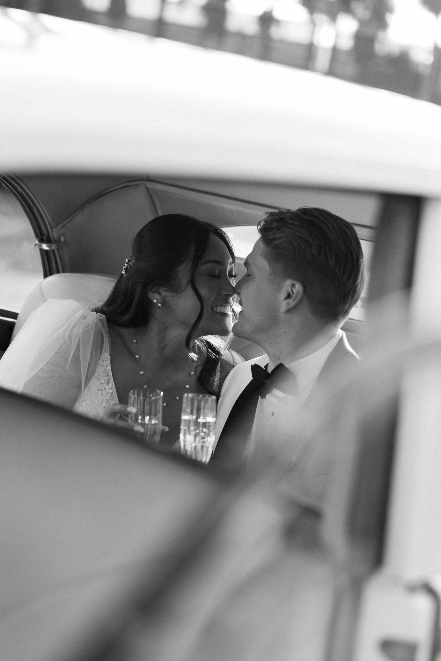 Black and white romantic car photo through window reflection.