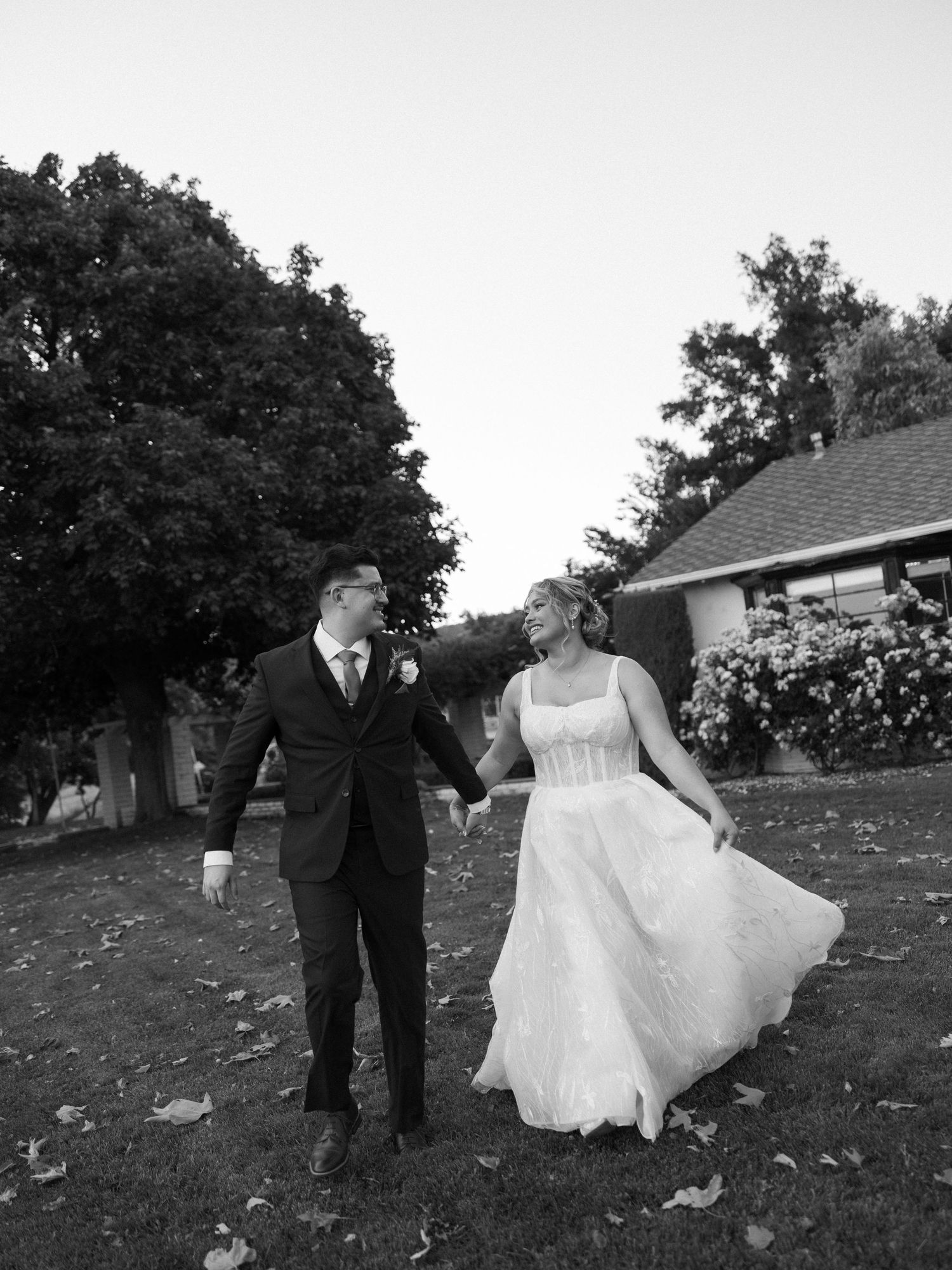 Black and white series of couple twirling and dancing on grass.