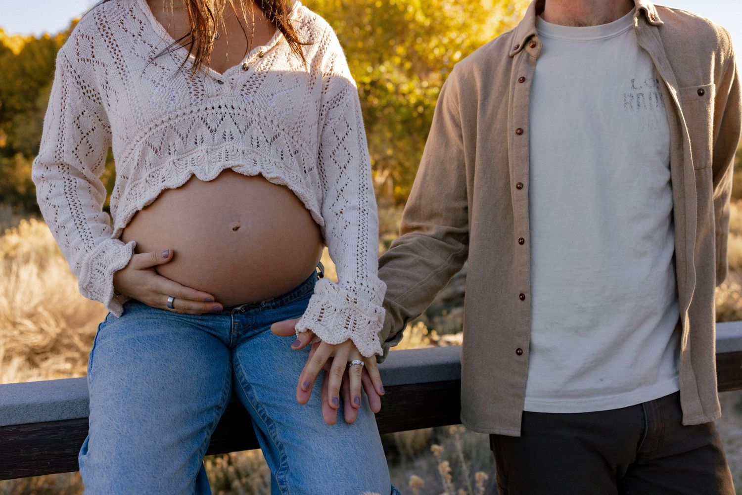 Cropped view of couple in casual attire sharing intimate moment outdoors.