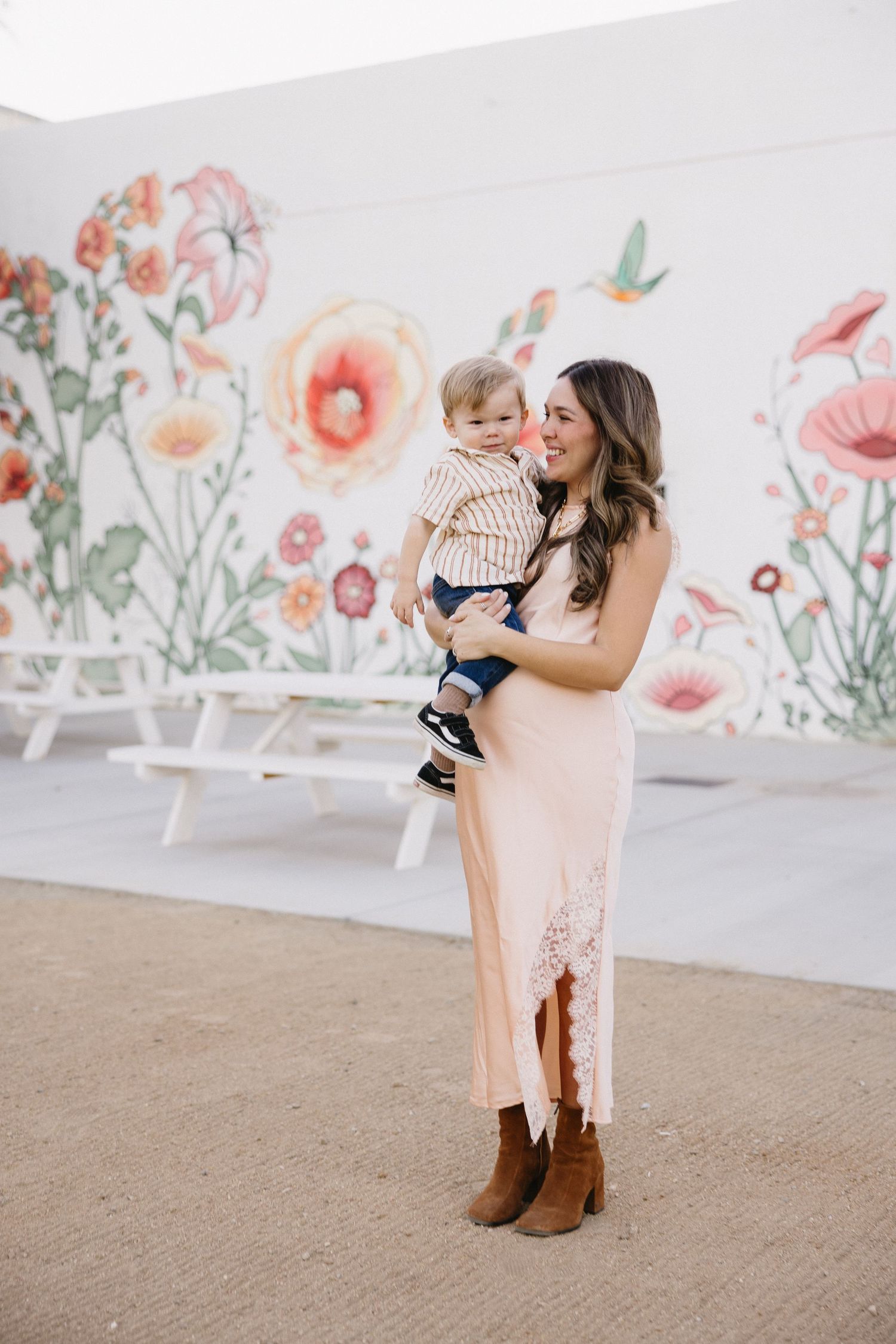 A joyful moment captured against a floral wall backdrop in casual western attire.