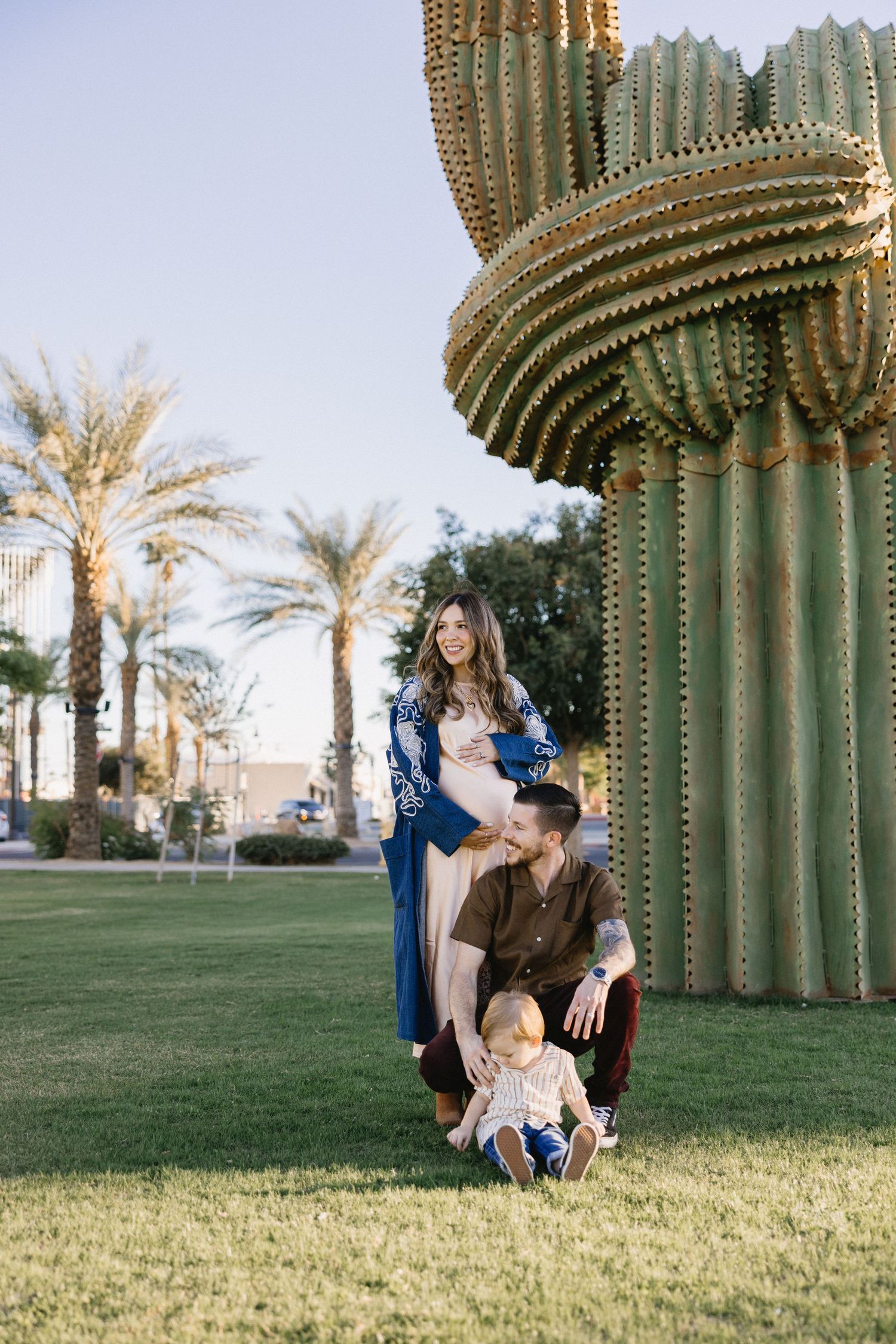 Family portrait session among tall saguaro cacti in a desert landscape.