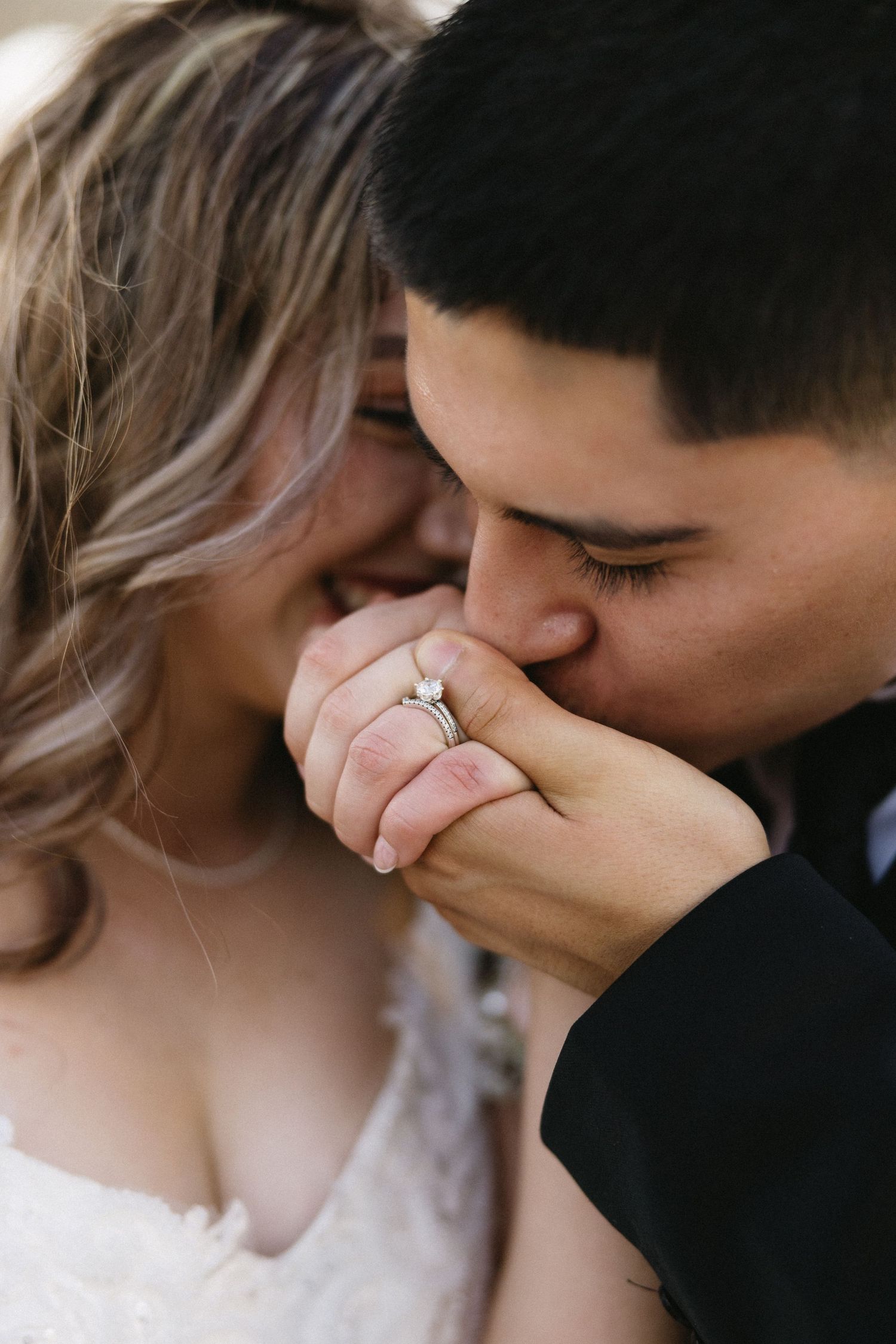 Close-up of tender romantic moment with wedding ring visible.