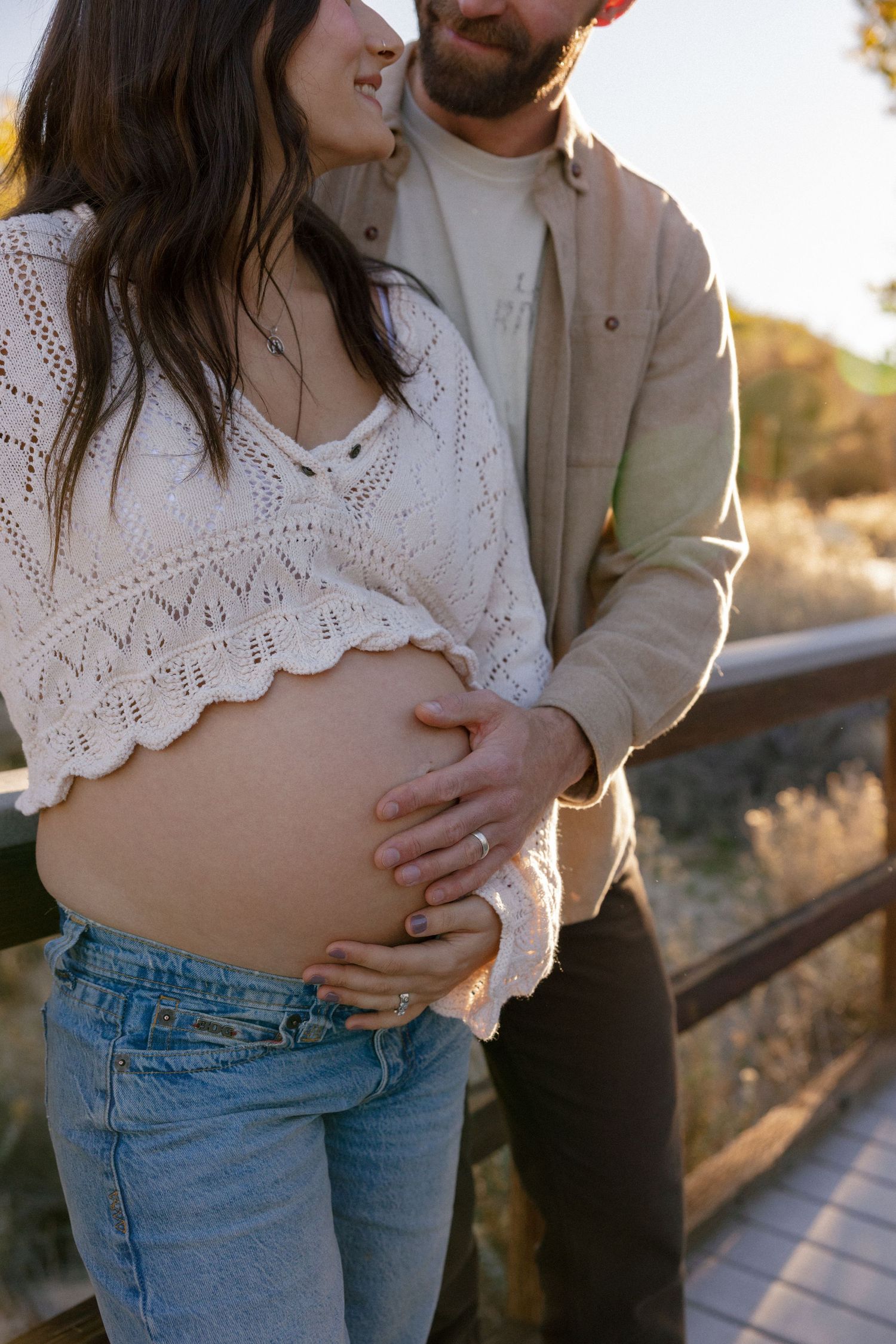 White lace top and denim jeans create intimate moment on outdoor walkway.