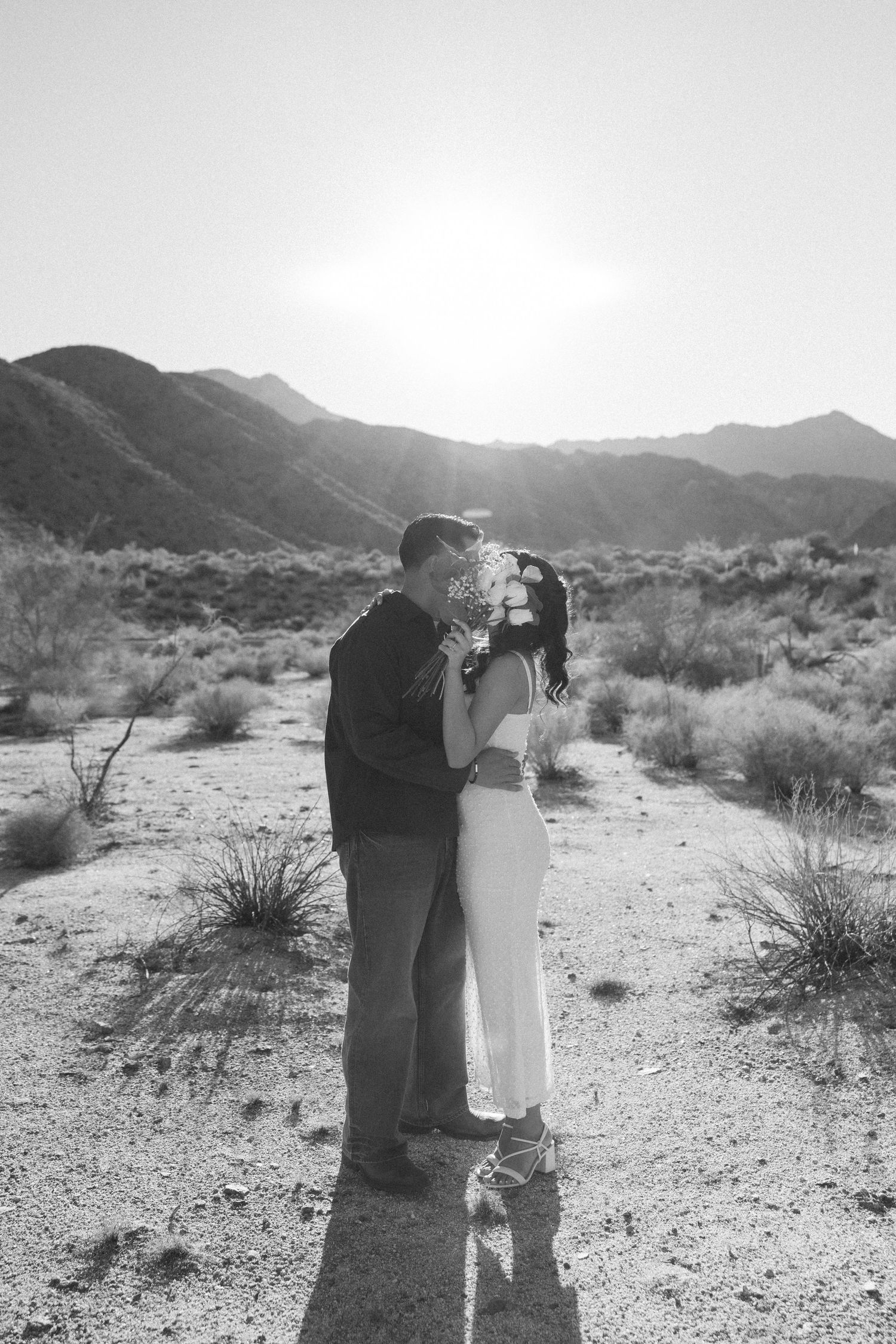 Black and white desert engagement photos with mountains in background.