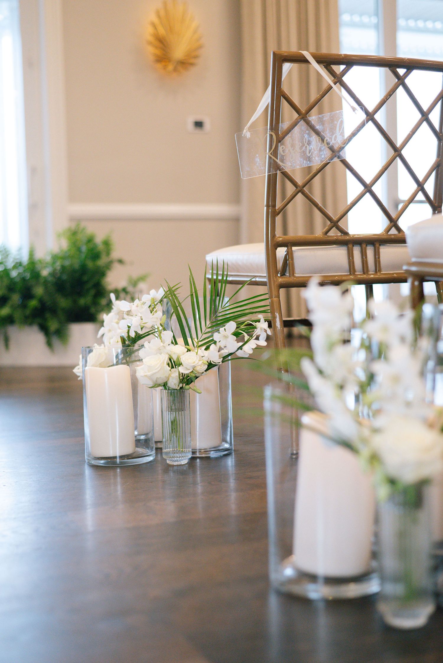 Elegant wedding reception table decor with white candles and floral centerpieces.