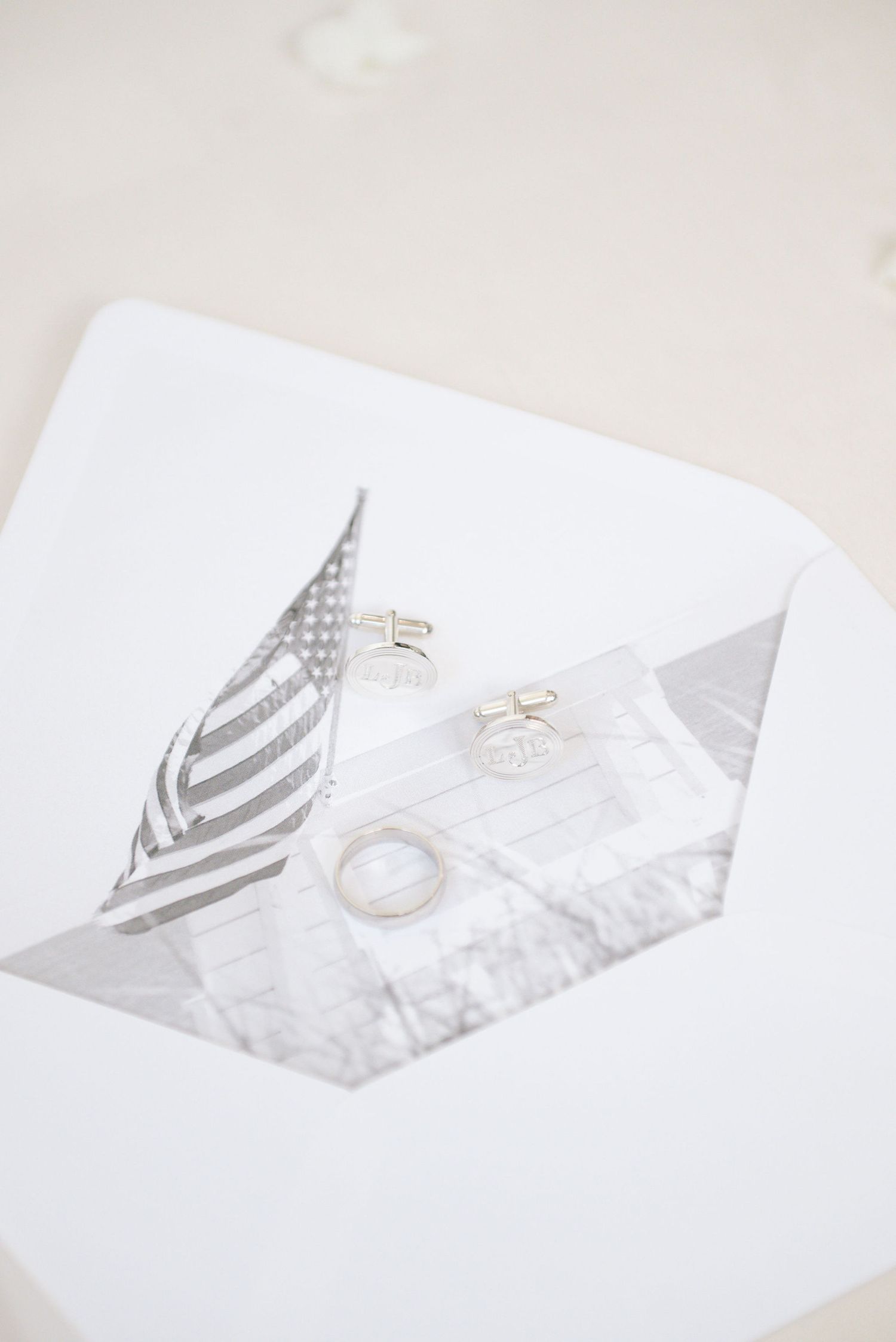 Minimalist white greeting card design featuring a small American flag and delicate gold accents.