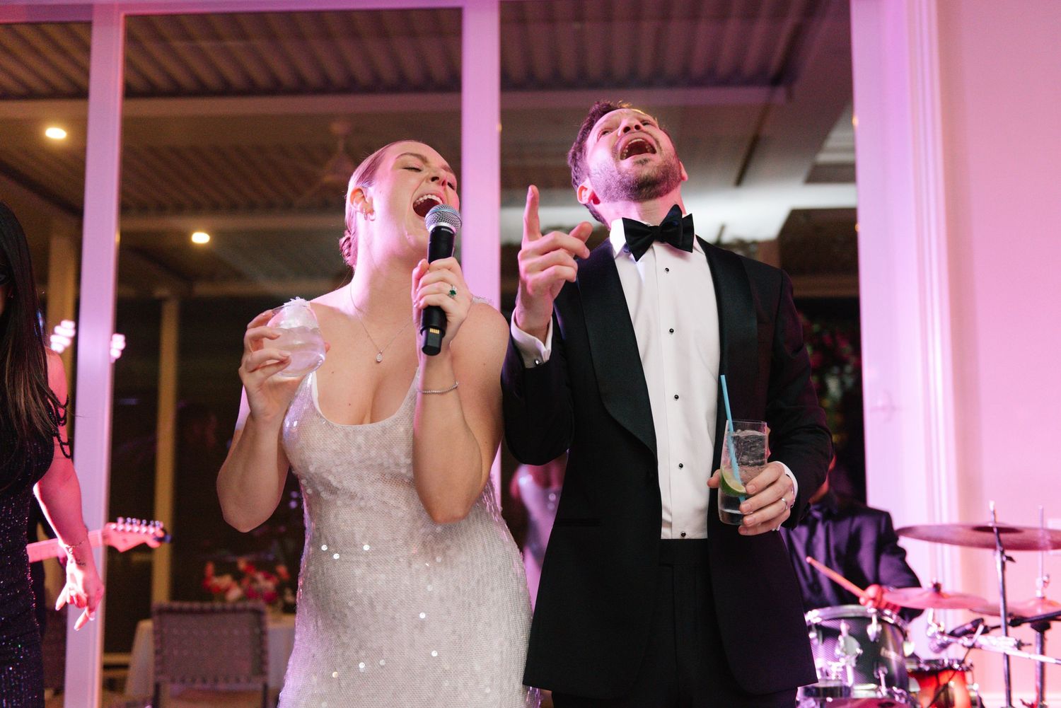 Wedding celebration with pink uplighting and guests dancing at an evening reception.
