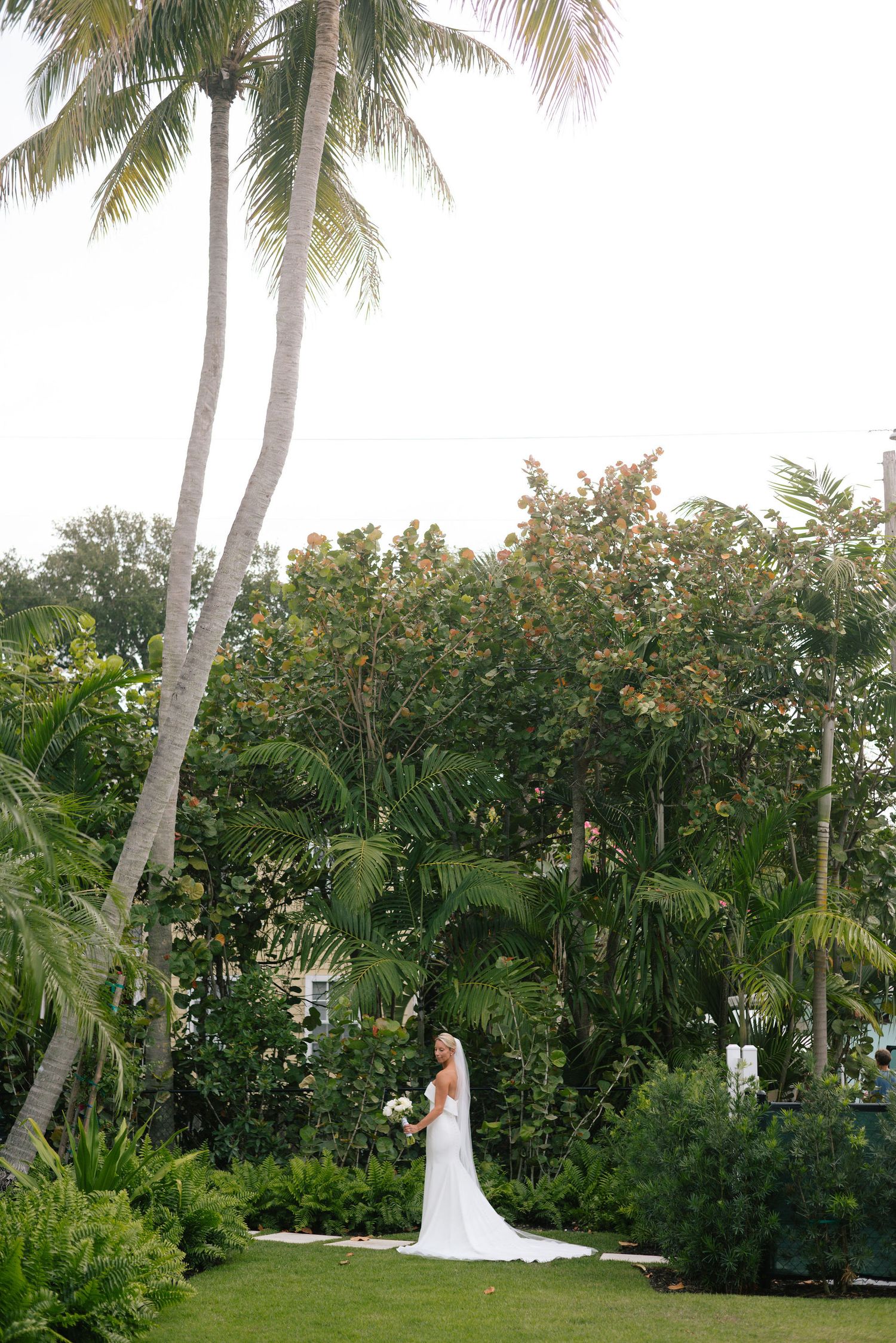 Tropical garden wedding setting with palm trees and lush greenery creating a natural backdrop.