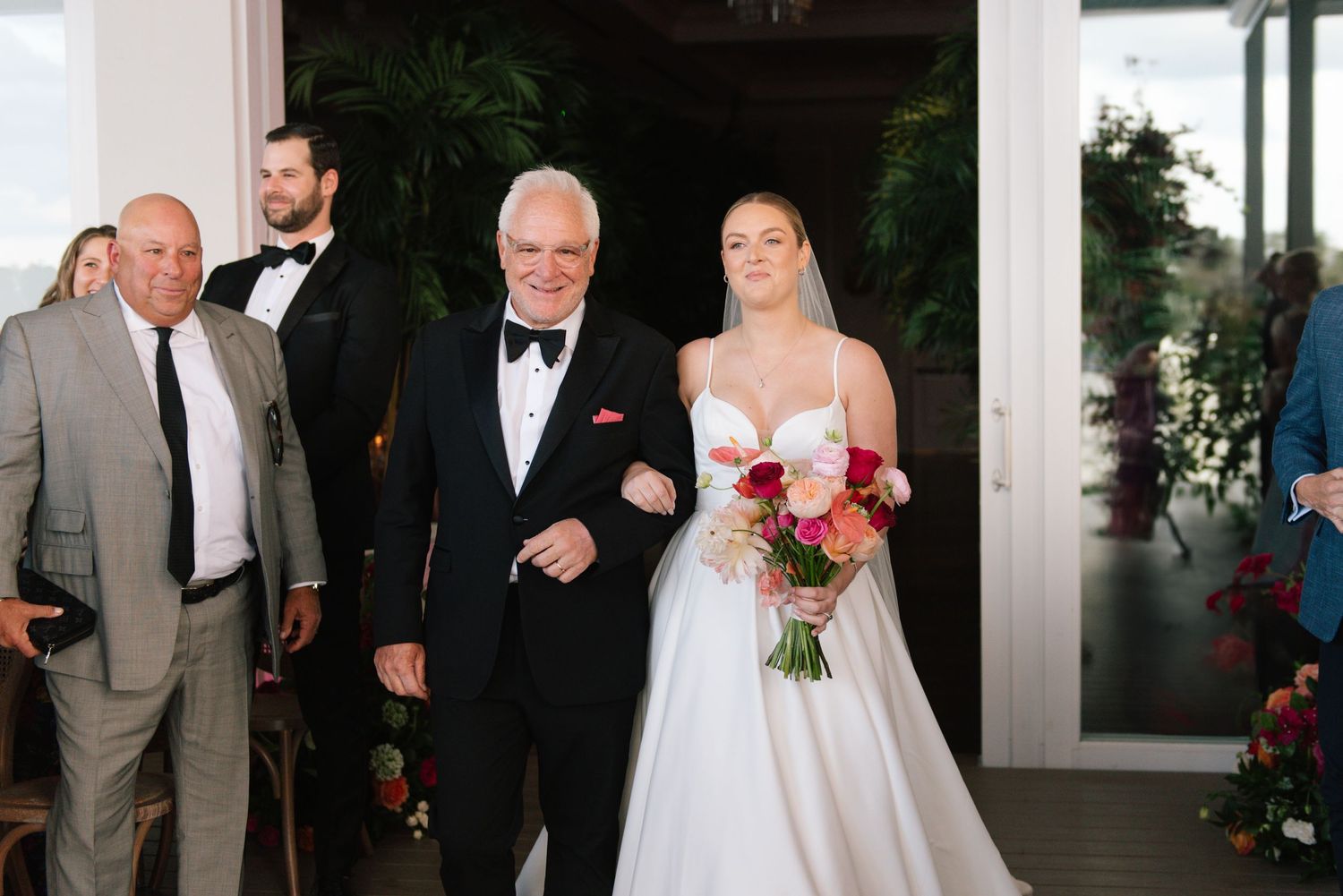 Elegant wedding ceremony setup with floral arrangements and formal attire.