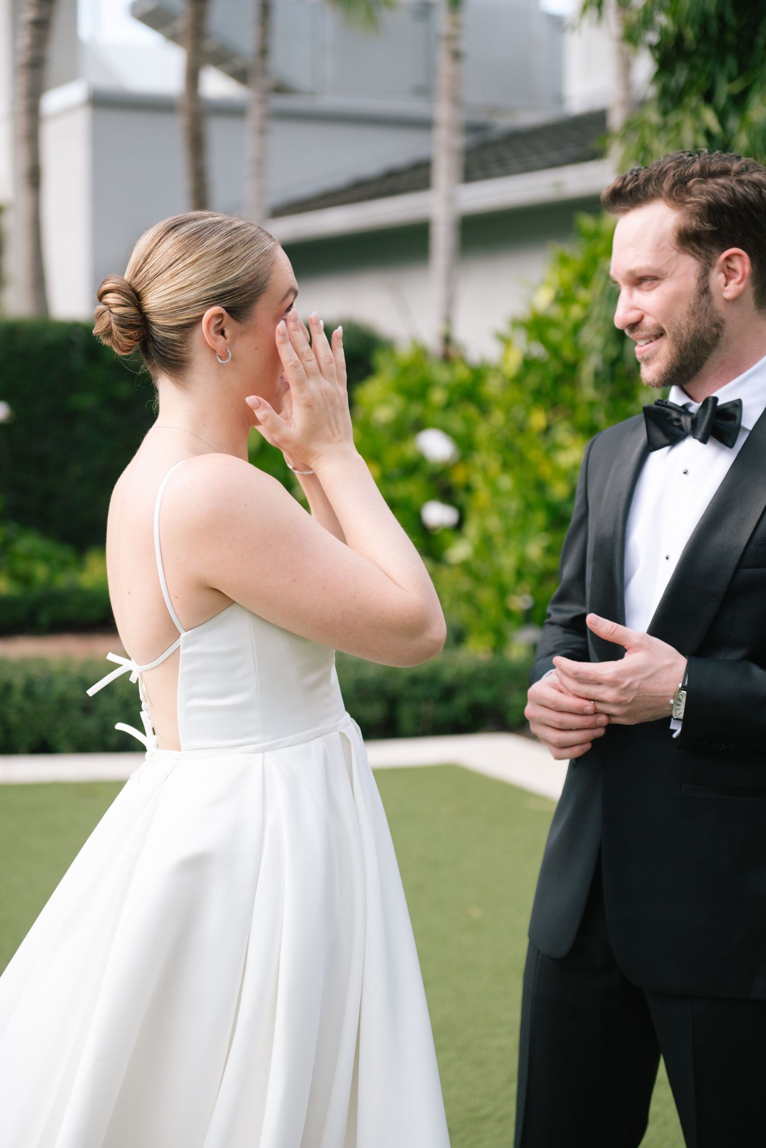 Couple having a first look moment outdoors with the bride showing emotional reaction.