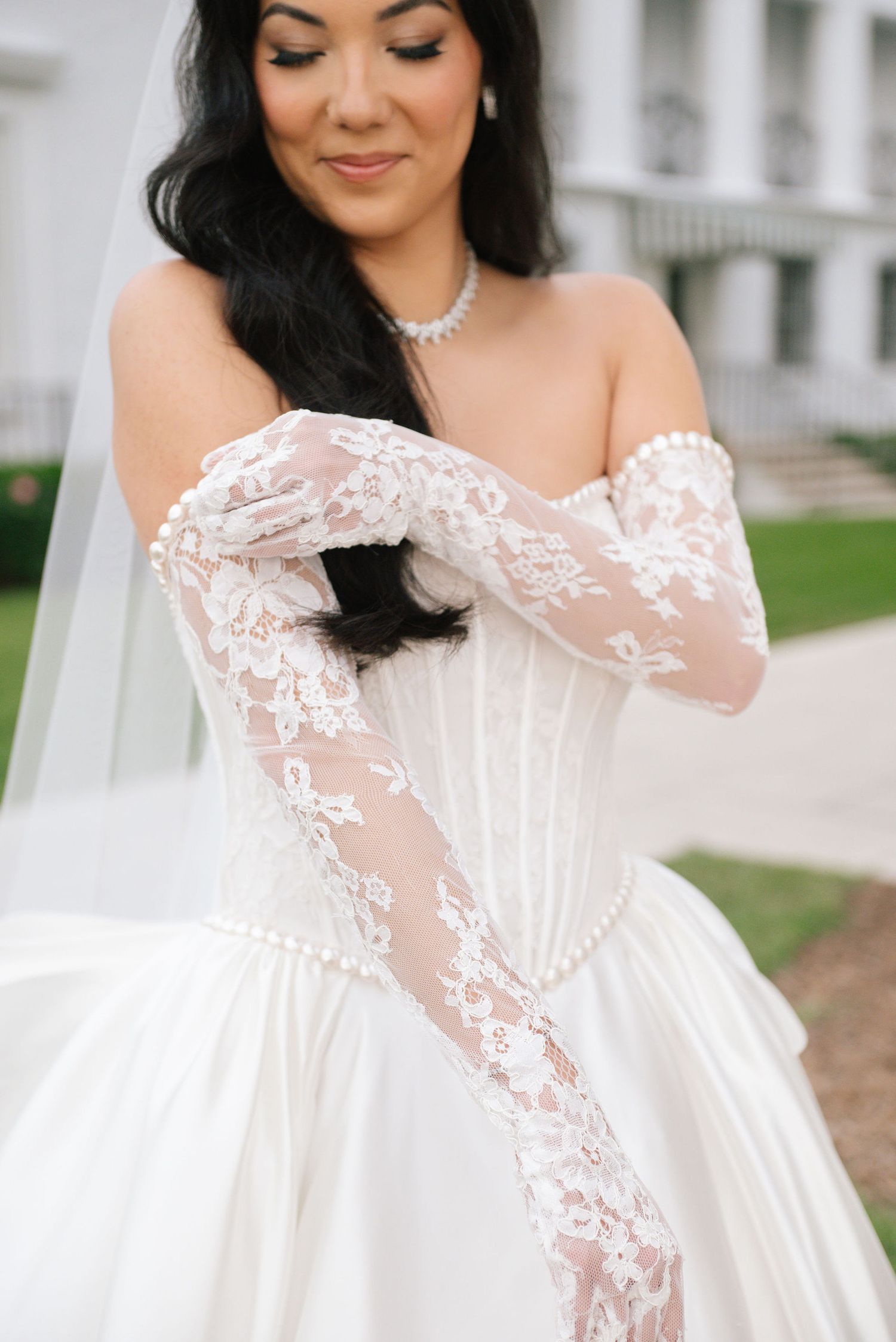 Close-up details of an ornate white wedding dress with delicate lace overlay and sweetheart neckline.