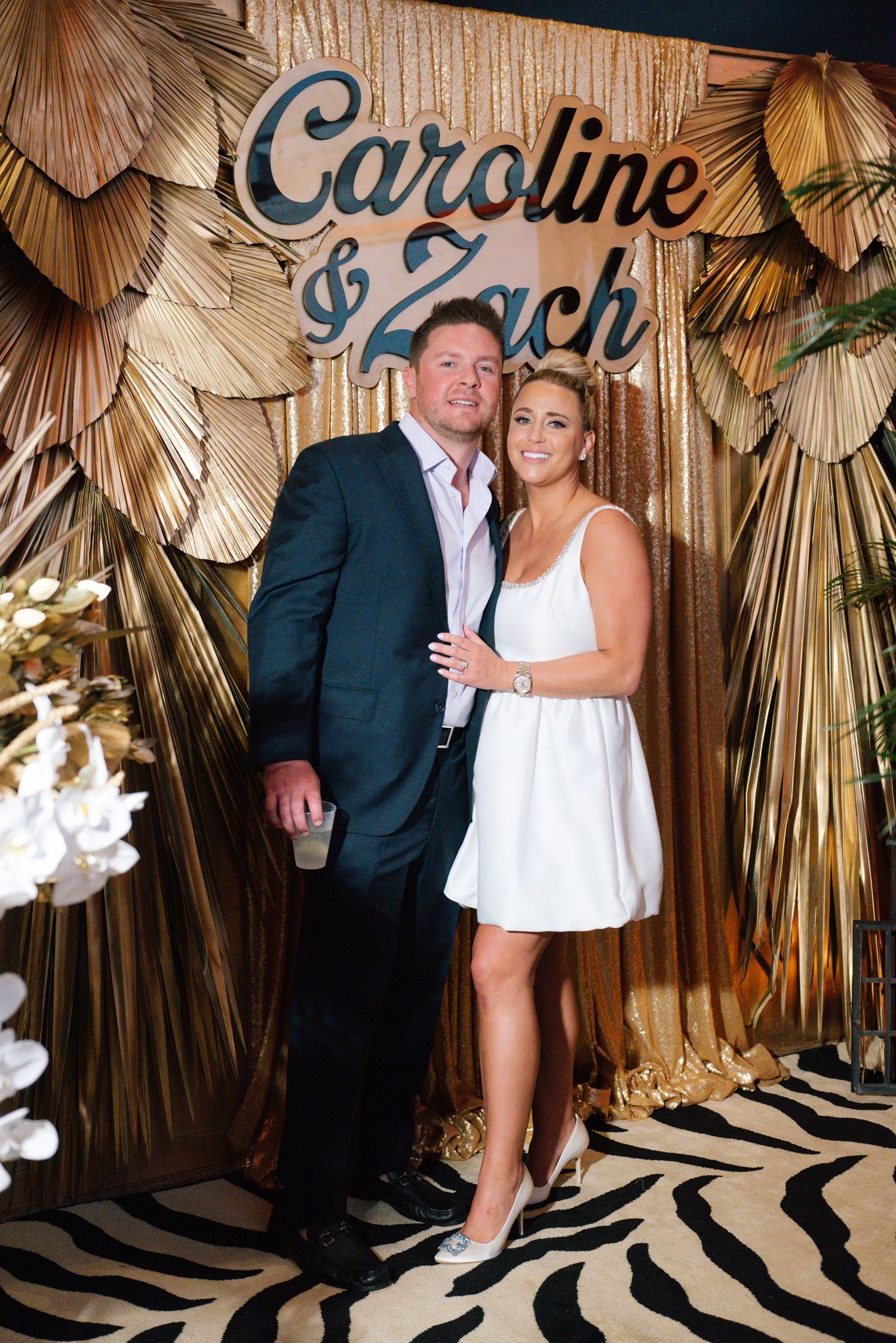 Gold palm leaf backdrop with decorative text display at an event venue.