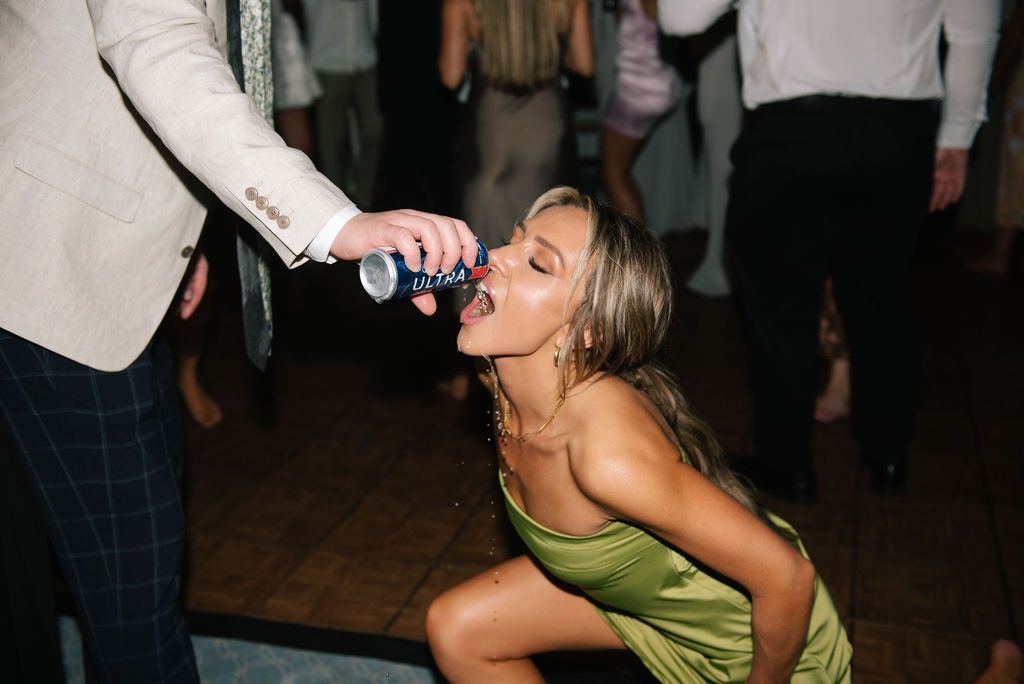 Wedding guests dance and celebrate during an energetic reception party.